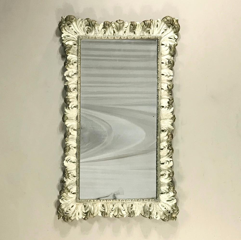 19th century carved Italian Baroque painted mirror was sculpted from solid wood then given its original painted finish highlighted in gold which has begun to show a nice patina. Finished the same all around in Baroque majesty, it can be mounted