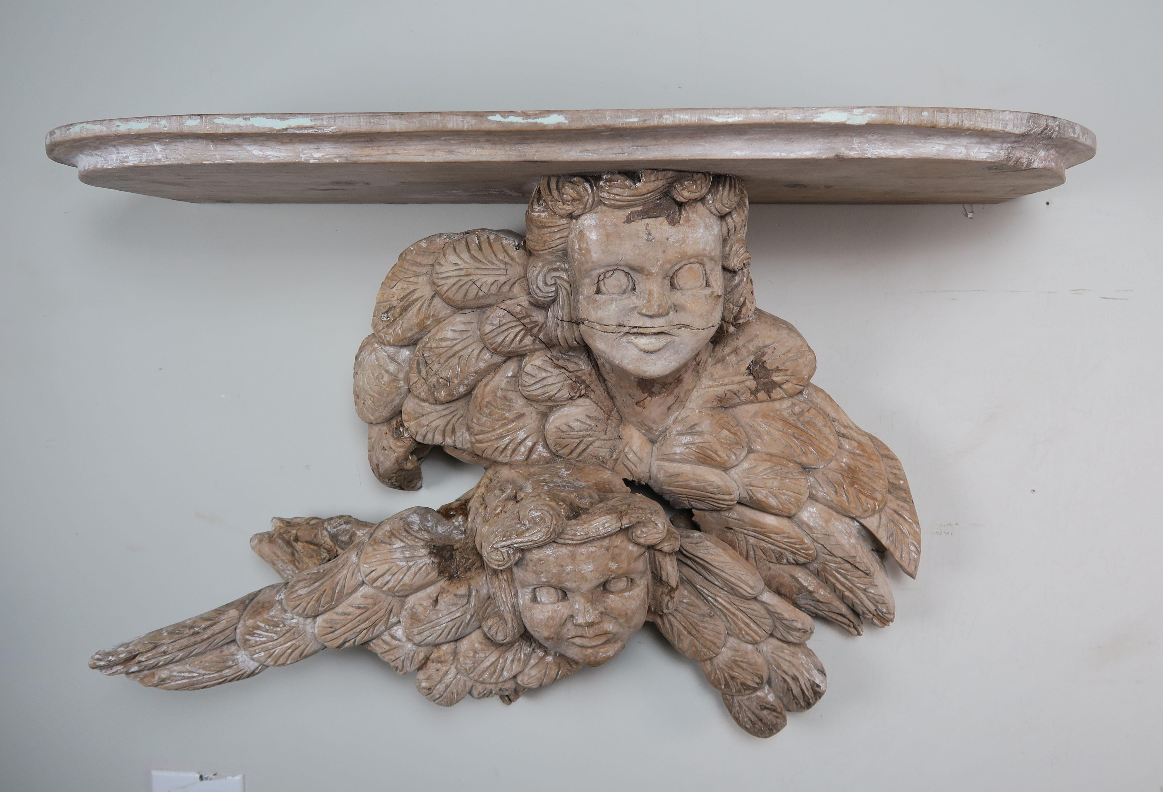 19th century hand carved Italian walnut shelf depicting a pair of winged cherubs.