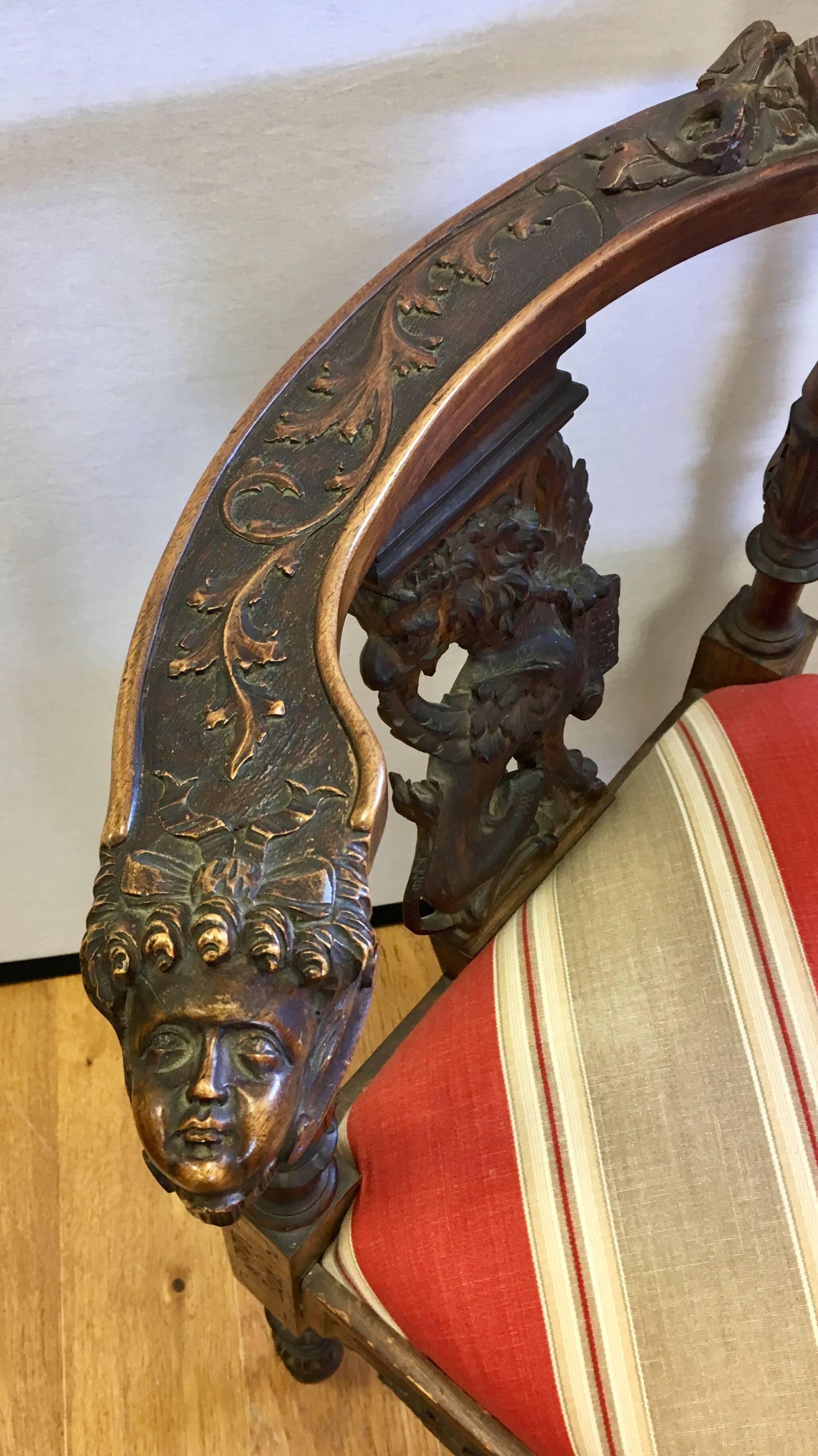 Antique 19th century mahogany corner chair features intricate hand-carved cherub heads on the front arms and back; carved griffins on both back splats. New upholstery on seat.
  