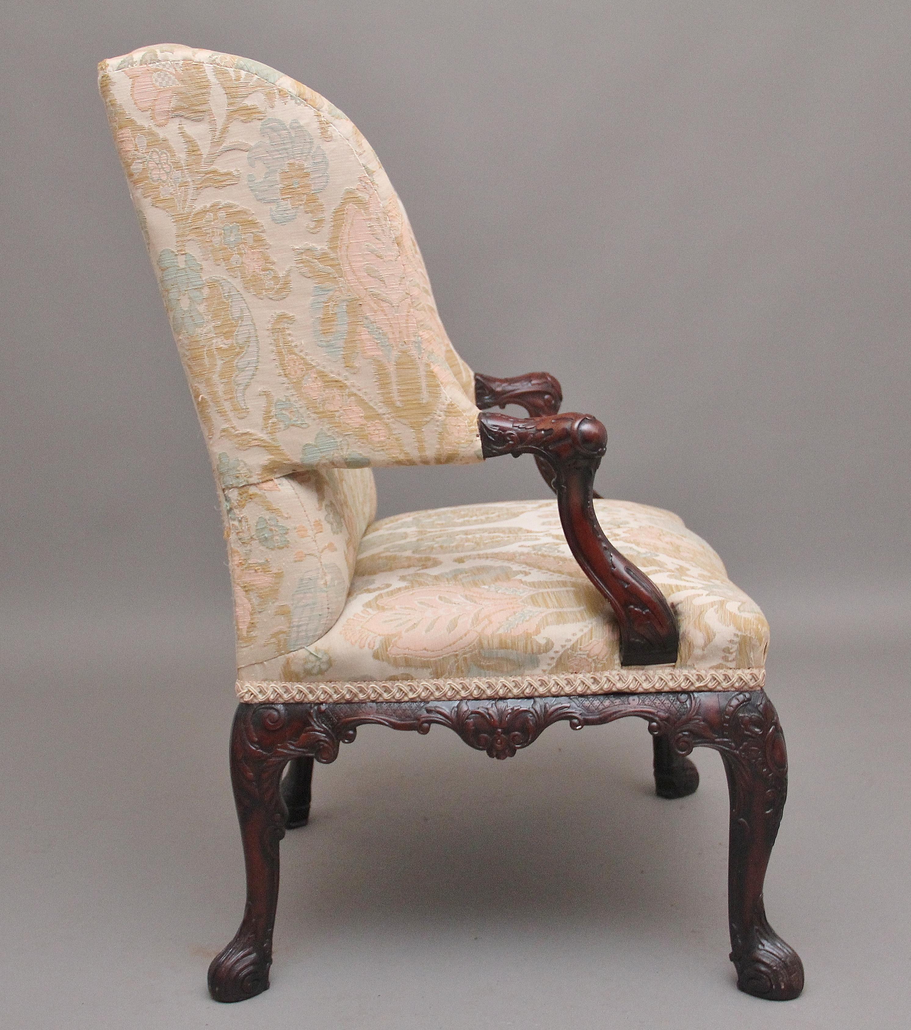 19th Century carved mahogany library armchair in the Chippendale style, upholstered in a cream fabric with a decorative floral pattern, high shaped back with a large cushioned seat, nice shaped arm supports, lovely carved mahogany frame