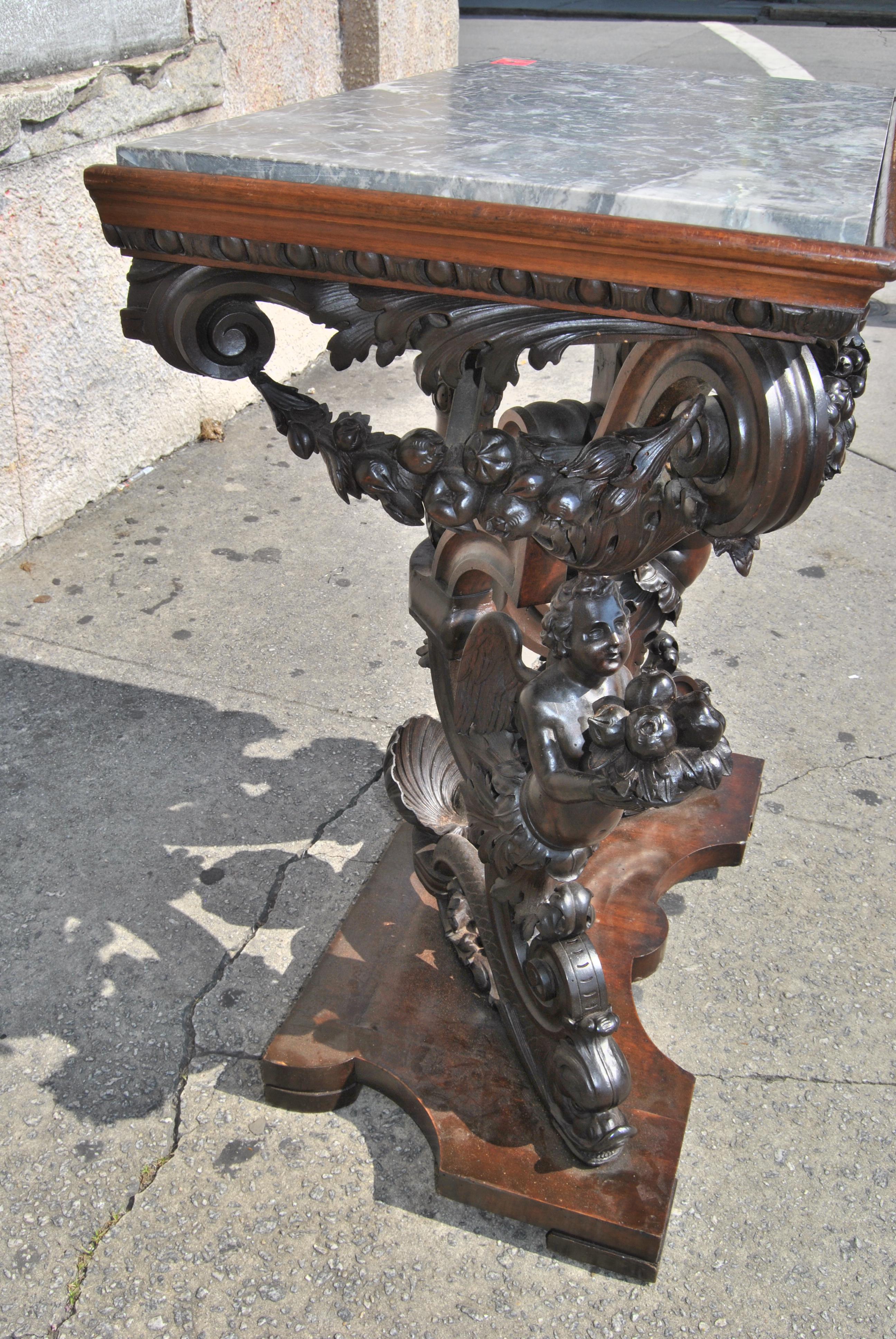 This is a solid mahogany hall table / side table / end table / lamp table made in England, circa 1860. This table exhibits some of the finest hand carving you will ever see. It is full of festooned garlands of fruits and flowers. There are 2 winged
