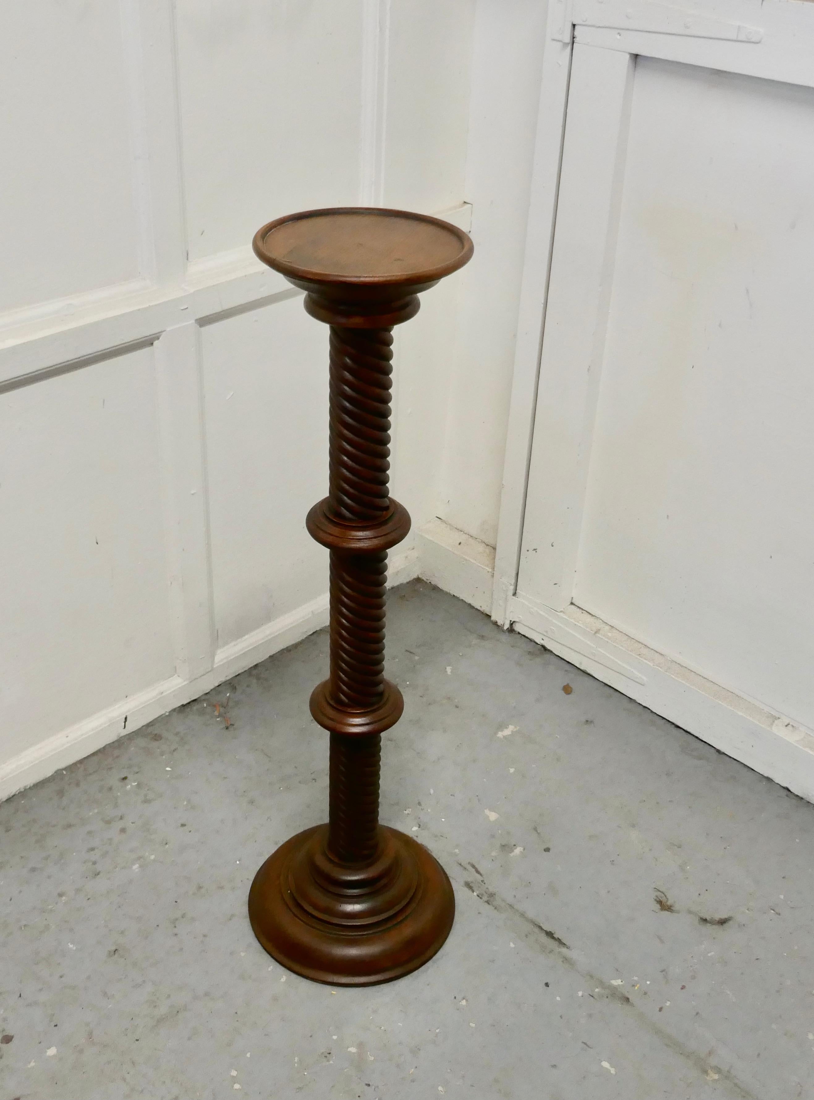 19th century carved mahogany pedestal torchere

The column has a tight barley twist turning, both top and bottom are round, the top has a small lip and the base is stepped 
The column is in the Classical style and has a multitude of uses, for a