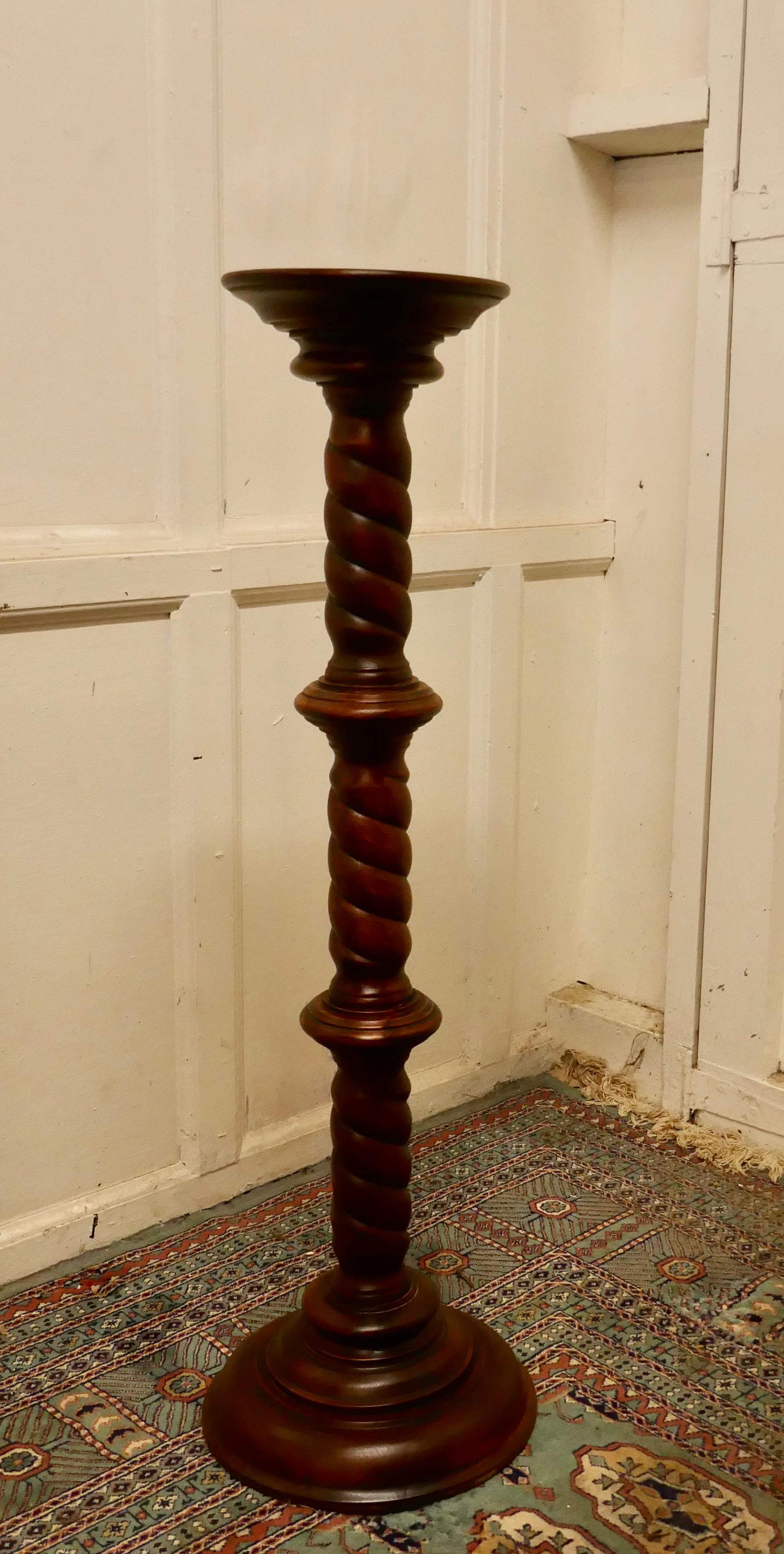 19th century carved mahogany pedestal torchere

The column has a barley twist turning, both top and bottom are round, the top has a small lip and the base is stepped 
The Column is in the Classical style and has a multitude of uses, for a lamp,