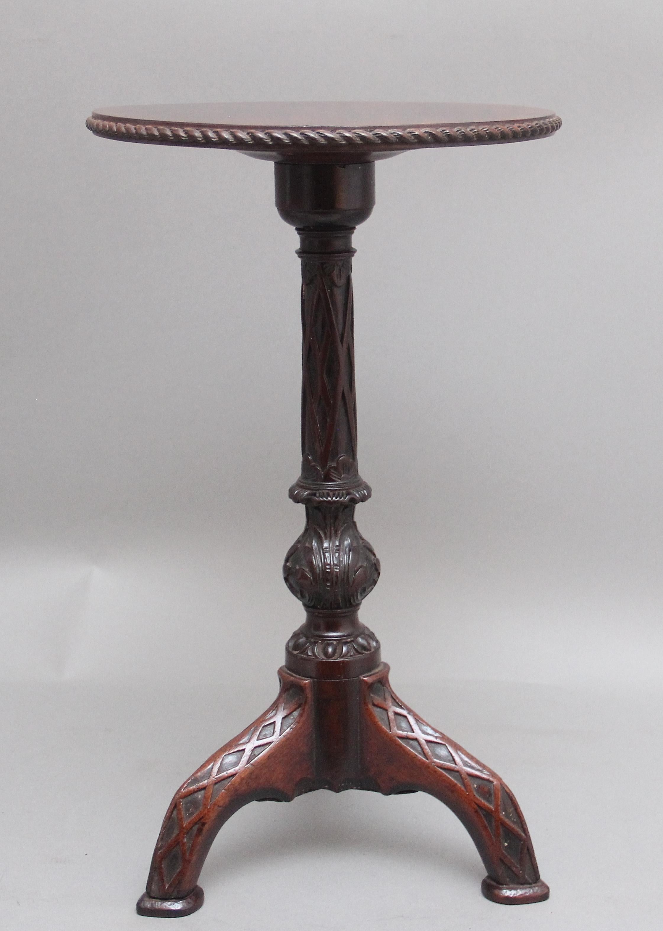 A highly decorative early 19th Century carved mahogany tripod table, having a nice figured circular top with a gadrooned edge supported on an elegant carved column terminating on three carved shaped legs.  Circa 1830.