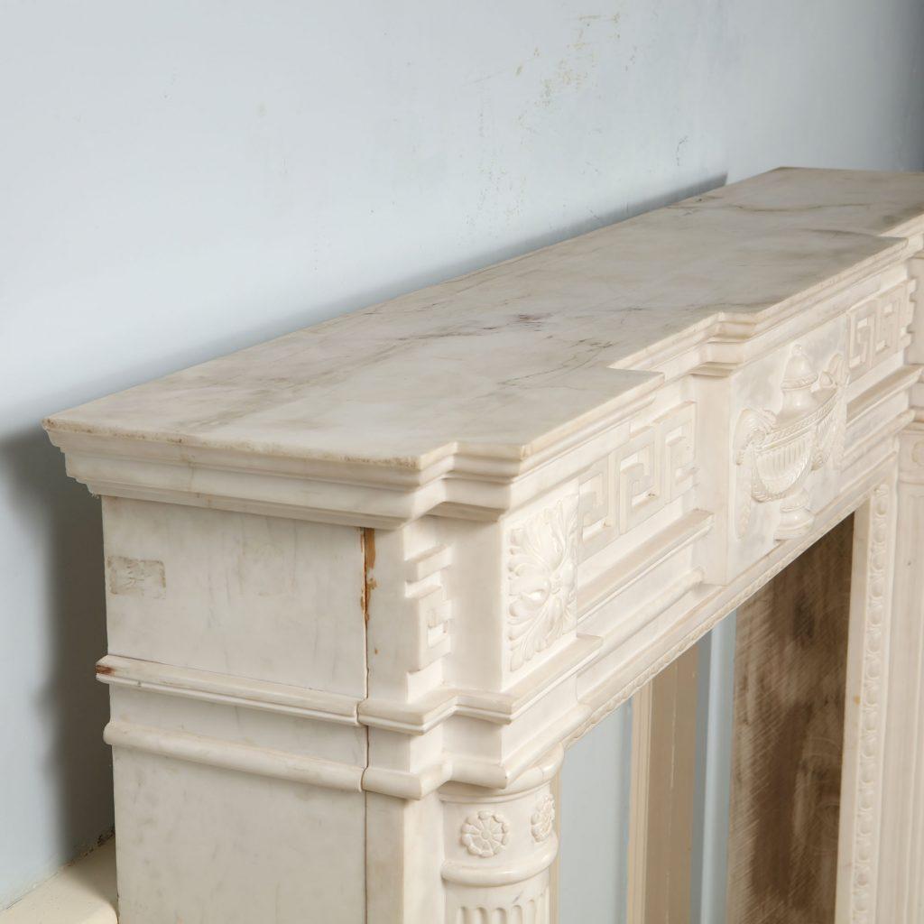 A fine 19th century Statuary marble fire surround the breakfront mantel (fireplace) above a central tablet carved neoclassical vase, Greek Key borders and supported on fluted half column pilasters. The aperture with egg and dart moldings.
England,