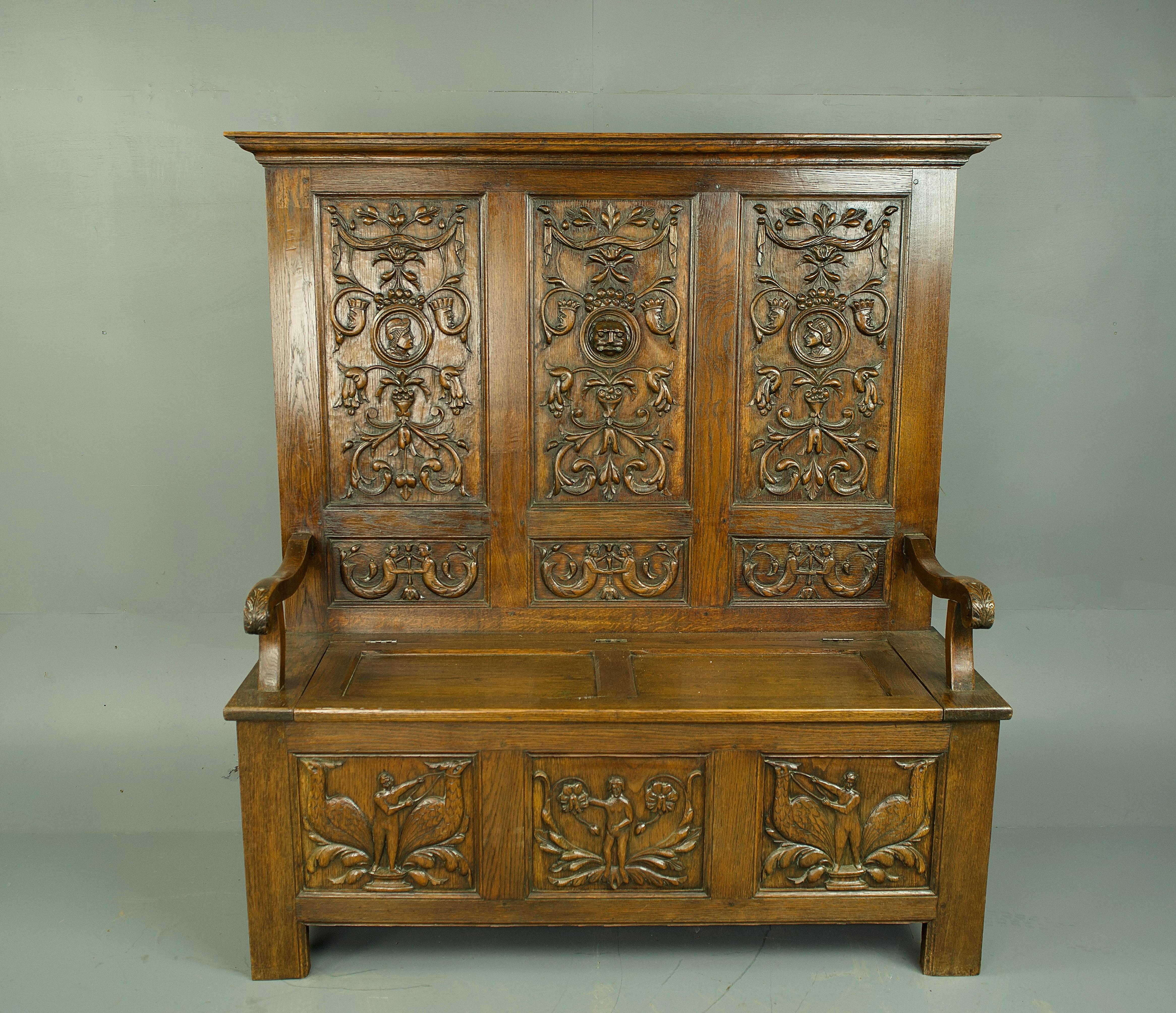 a fine 19th century carved oak hall bench with very imposing hand carved panels .
The bench exemplifies the  craftsmanship and design aesthetics of the Tudor era .
with grand and intricately detailed hand carved panels to the back board and base