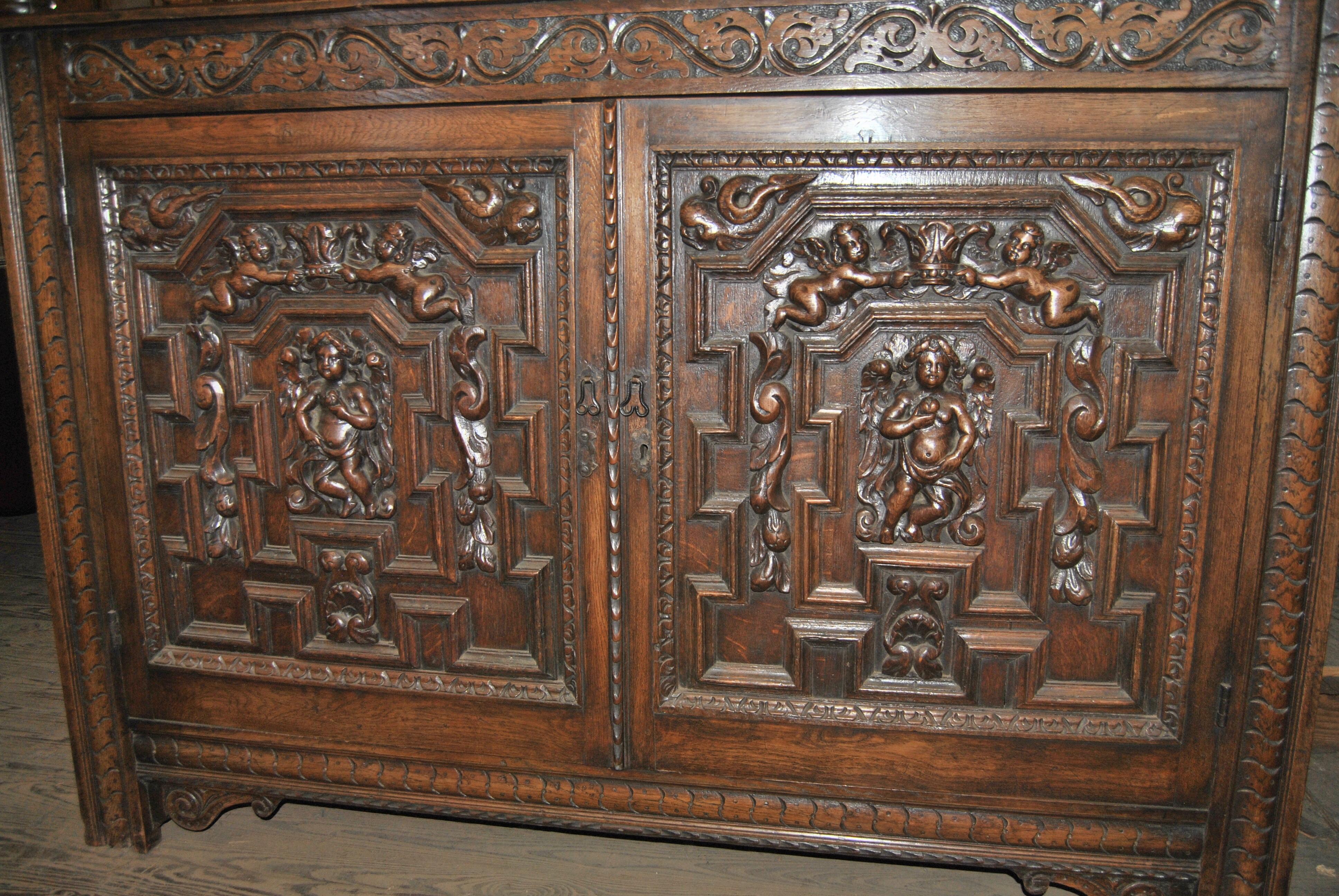 This is a fabulous quality, heavily carved solid oak court cupboard, made in England, circa 1850. The geometric moldings on the panels and doors are absolutely unbelievable. The quality and depth of all the hand carving is amazing. The door on the
