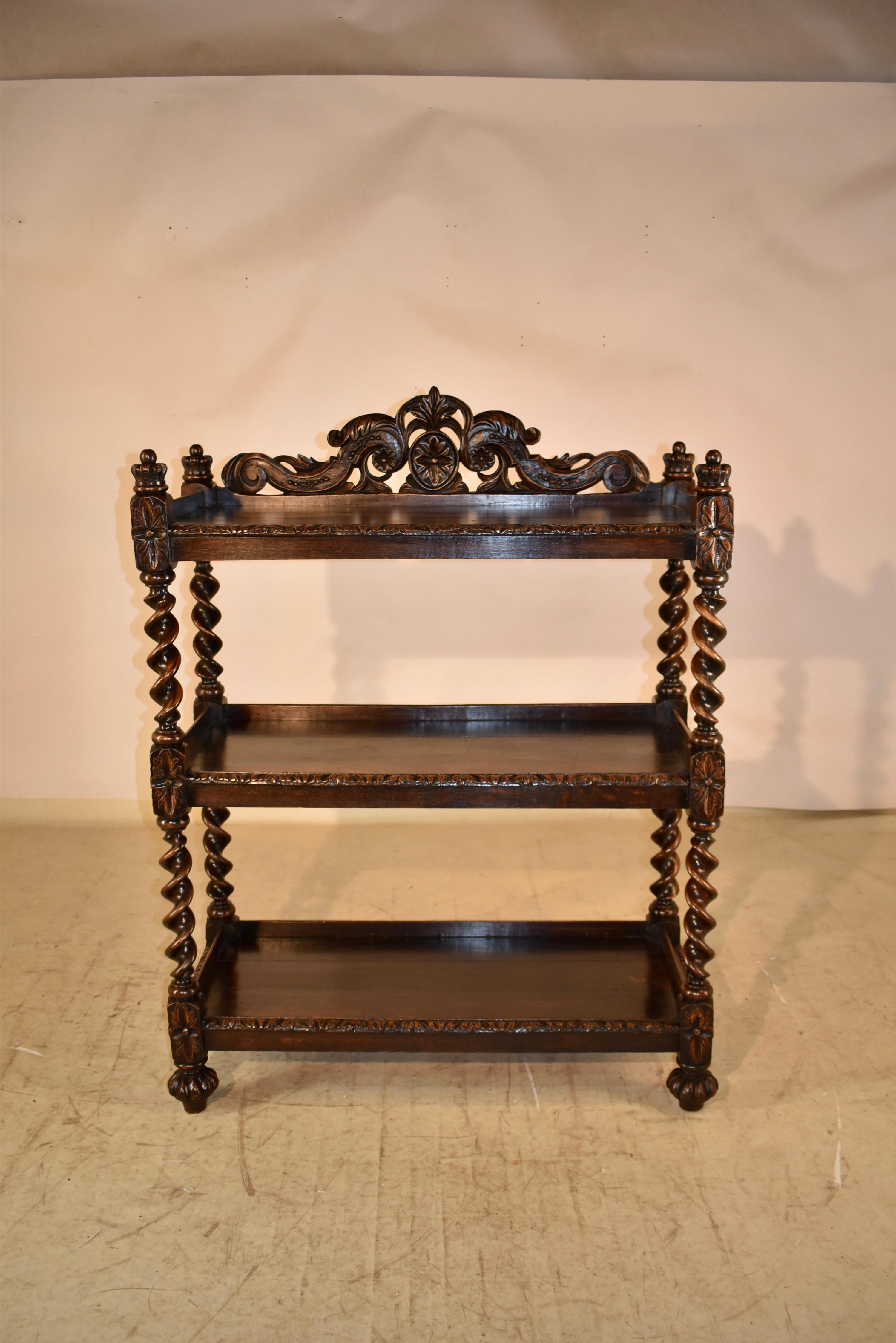 19th century oak dessert buffet from France. On the top there is a glorious hand carved backsplash and four hand carved crown finials. There are three shelves, all with carved front beveled edges, and galleries on three sides. The carved and beveled