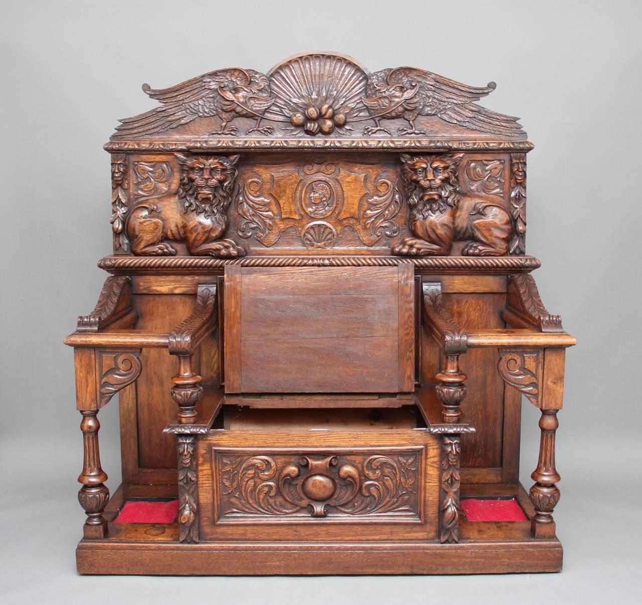 A stunning 19th century carved oak hall bench profusely carved all-over with lions, birds, faces and all manor of things, the central seat lifts up to reveal a compartment for storage, the seat is flanked on either side by a place to put your