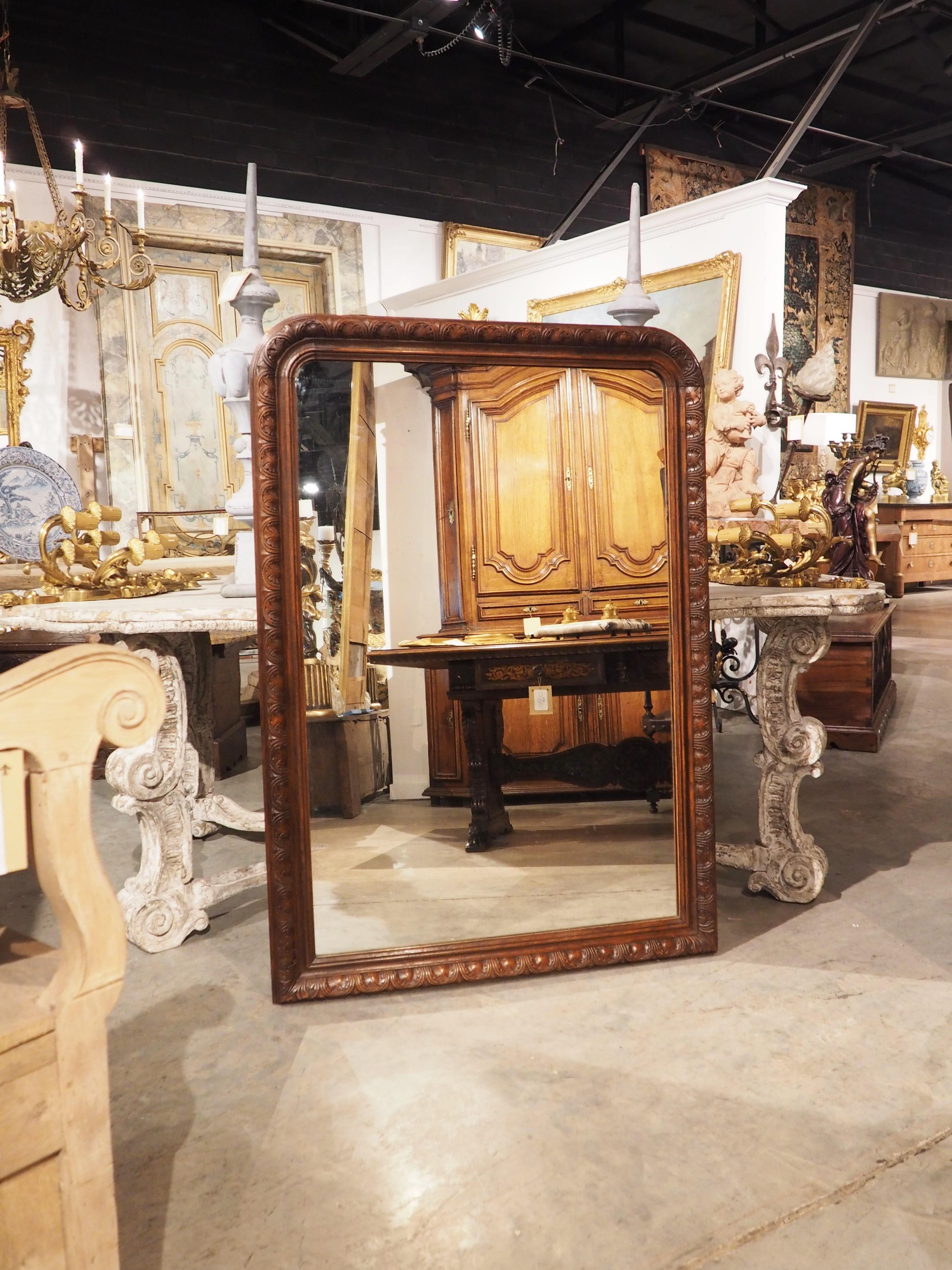 An unusual production of a timeless piece of furniture/decorative accessory, this Louis Philippe style mirror features a wood frame with a rich, natural stain. Typically, a Louis Philippe mirror has a wooden frame covered with plaster or gesso,