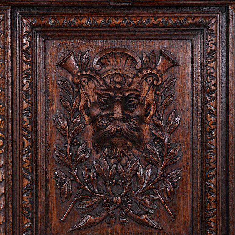 A most impressive and fine quality 19th century English Renaissance revival buffet in oak, profusely carved with a variety of vines and botanical motifs, the doors featuring finely carved faces and leaves etc. A central mirror is flanked by carved
