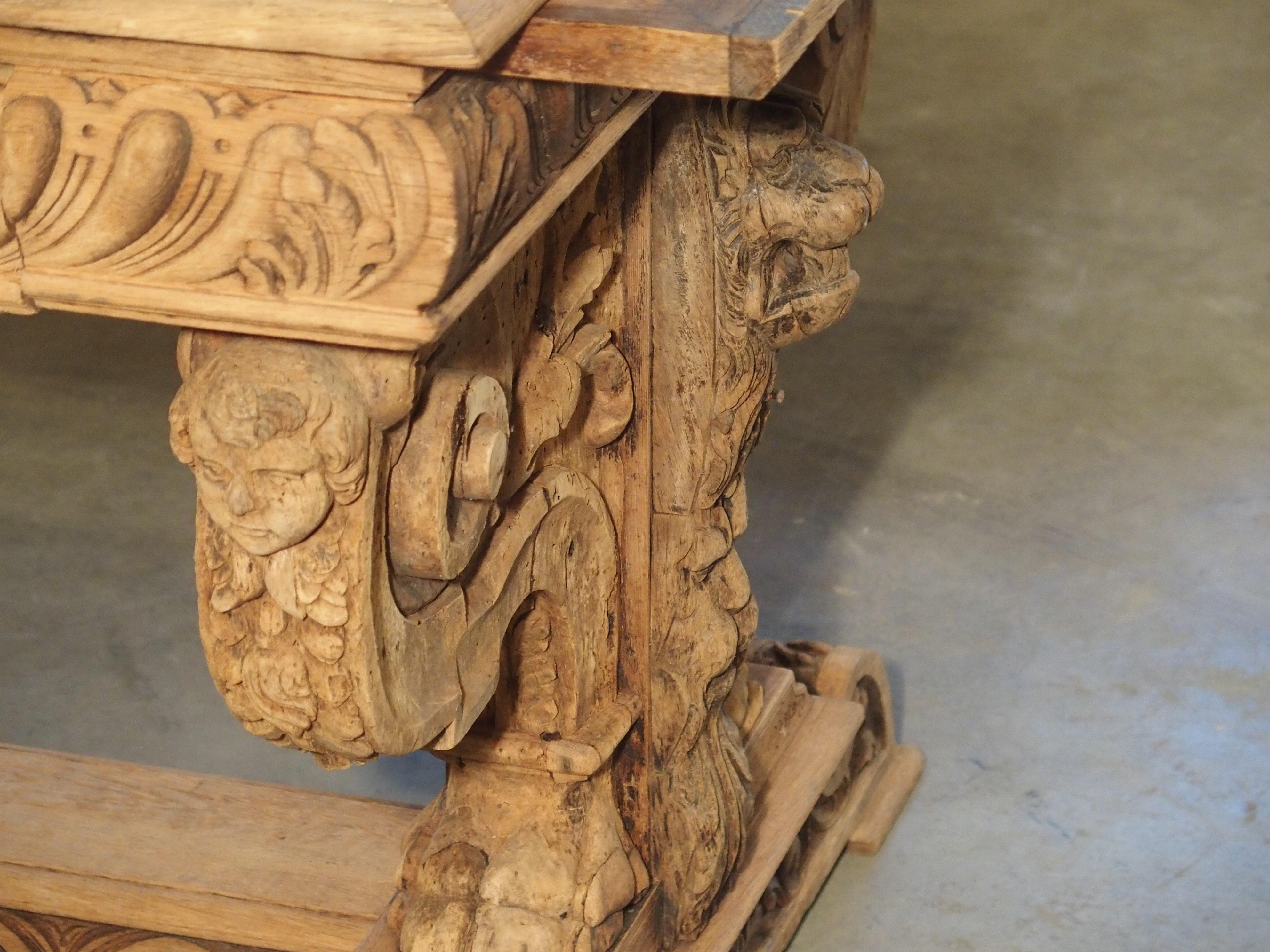 From France, circa 1860, this ornate, stripped oak desk has been carved in the Renaissance style and inset with a contemporary bluestone top. The stone has a blue-grey hue with white veining and visible fossils.

The wood that encases the stone