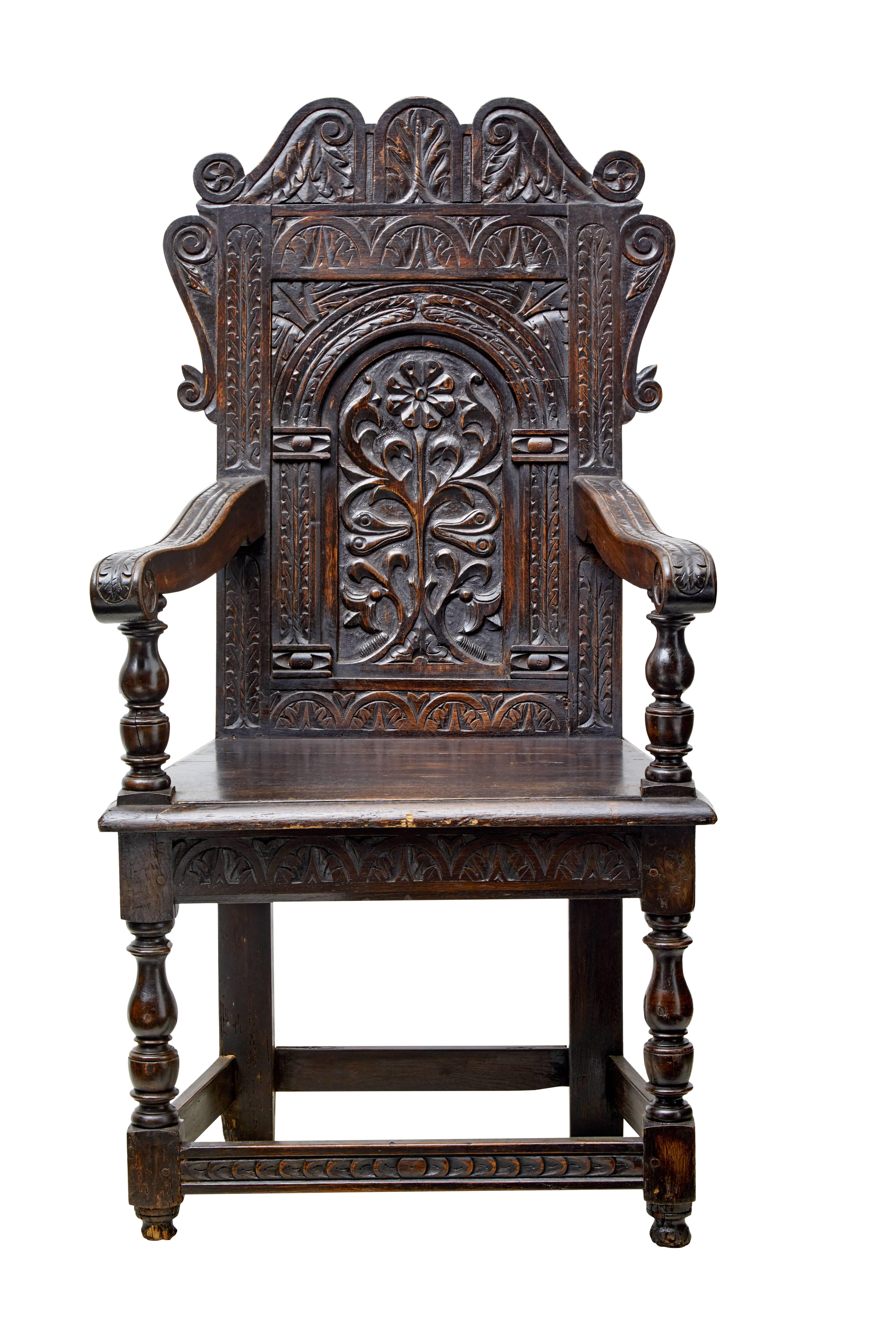Good quality carved oak wainscot, circa 1870.

Made in the 19th century using earlier elements which shows the beautifully carved back rest.

Scrolling arms supported by turned supports. Front turned legs united by rail.

Measures: Arm height