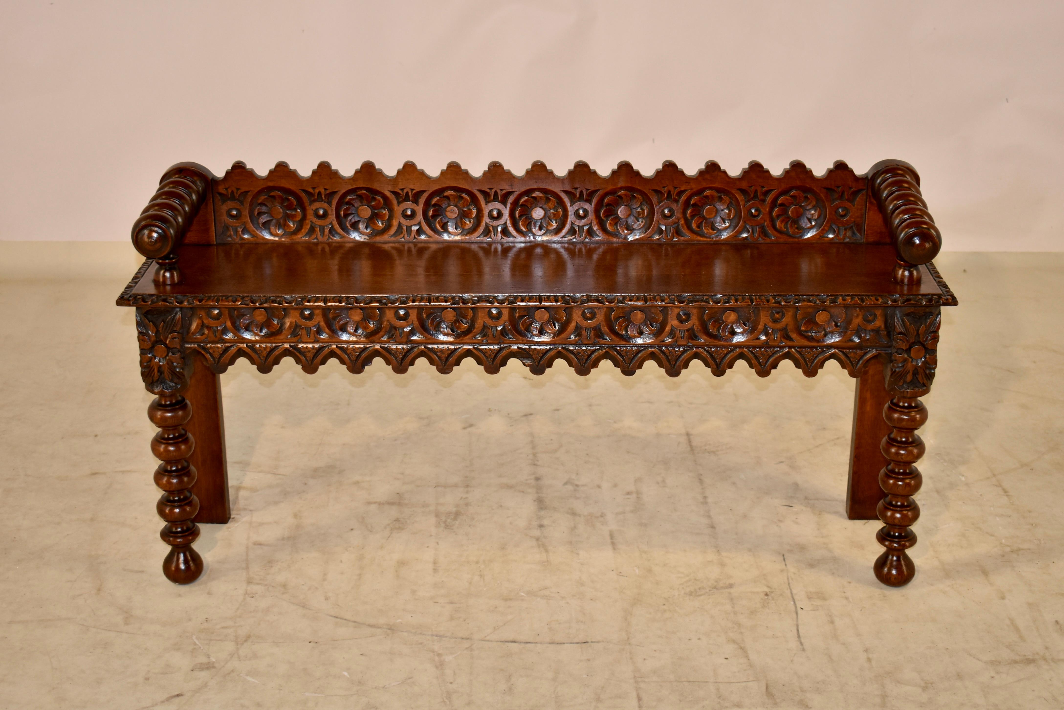 19th century English oak carved window seat with a lovely hand-carved and scalloped back, following down to hand turned arms, which are resting upon the seat.  The arm height is 24 inches.  The seat has a hand carved and beveled edge over a gorgeous