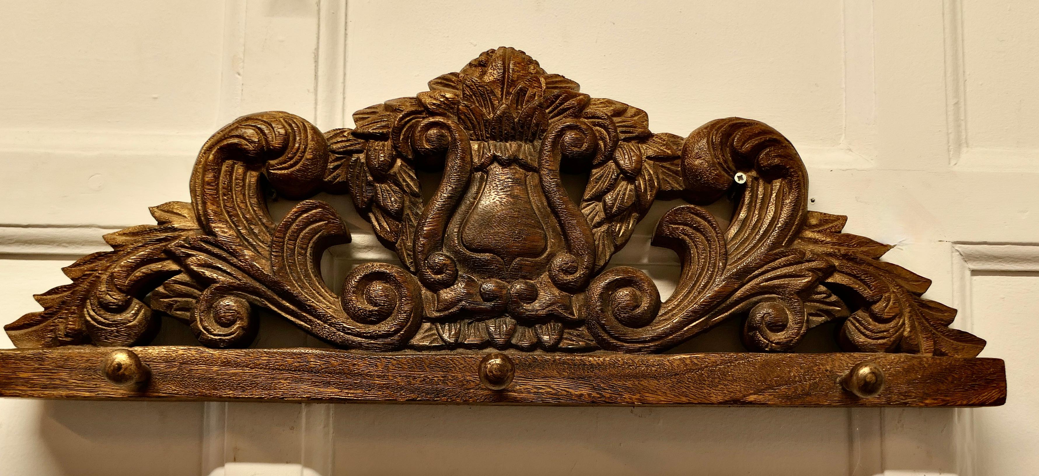 19th Century Carved OakWall Hanging Coat Rack 

 19th Century Carved Wall Hanging Coat Rack for coats umbrellas or hats

This is a solid carved wall piece, it is deeply carved with leaves and a shield, below there are 3 wooden coat hooks
The Rack is