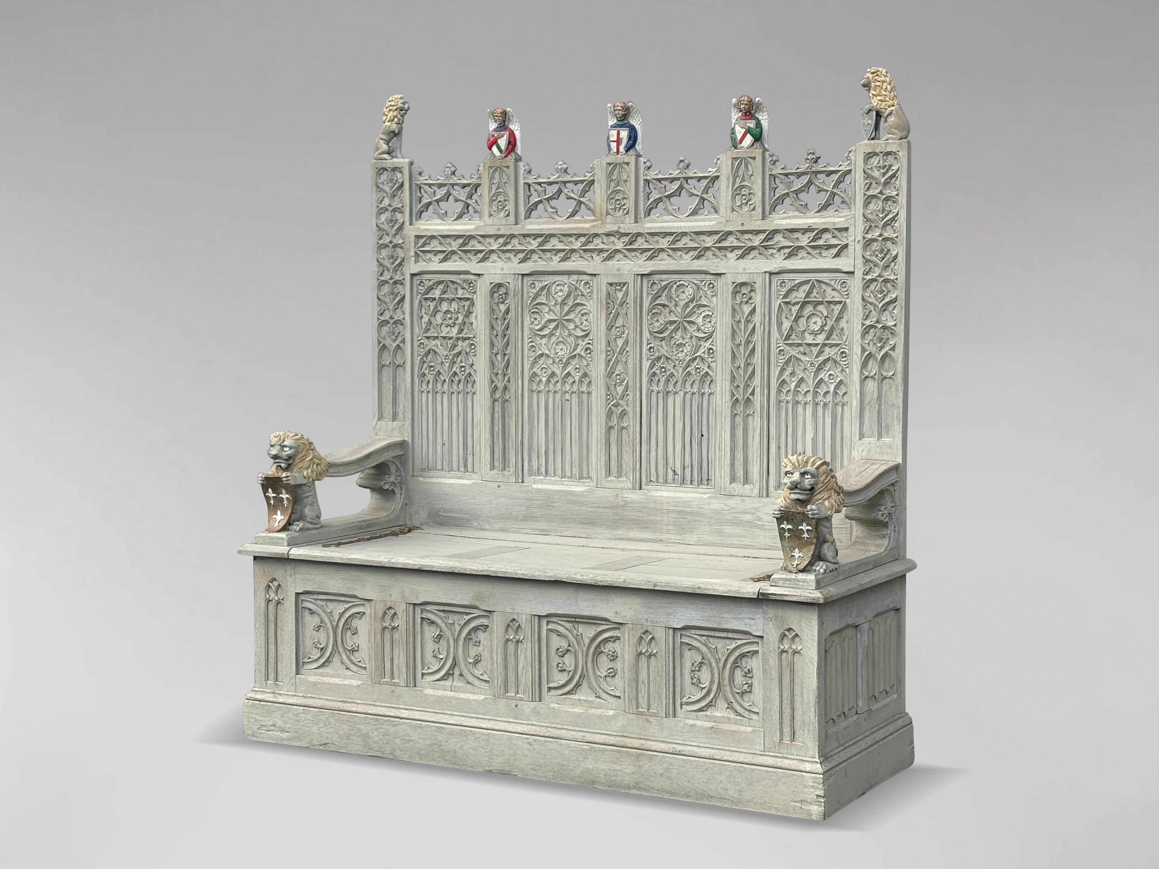This decorative late 19th-century carved painted solid oak Gothic revival hall bench is an exquisite piece that combines beauty and functionality.  The bench embodies the Gothic revival style, which is known for its intricate designs and