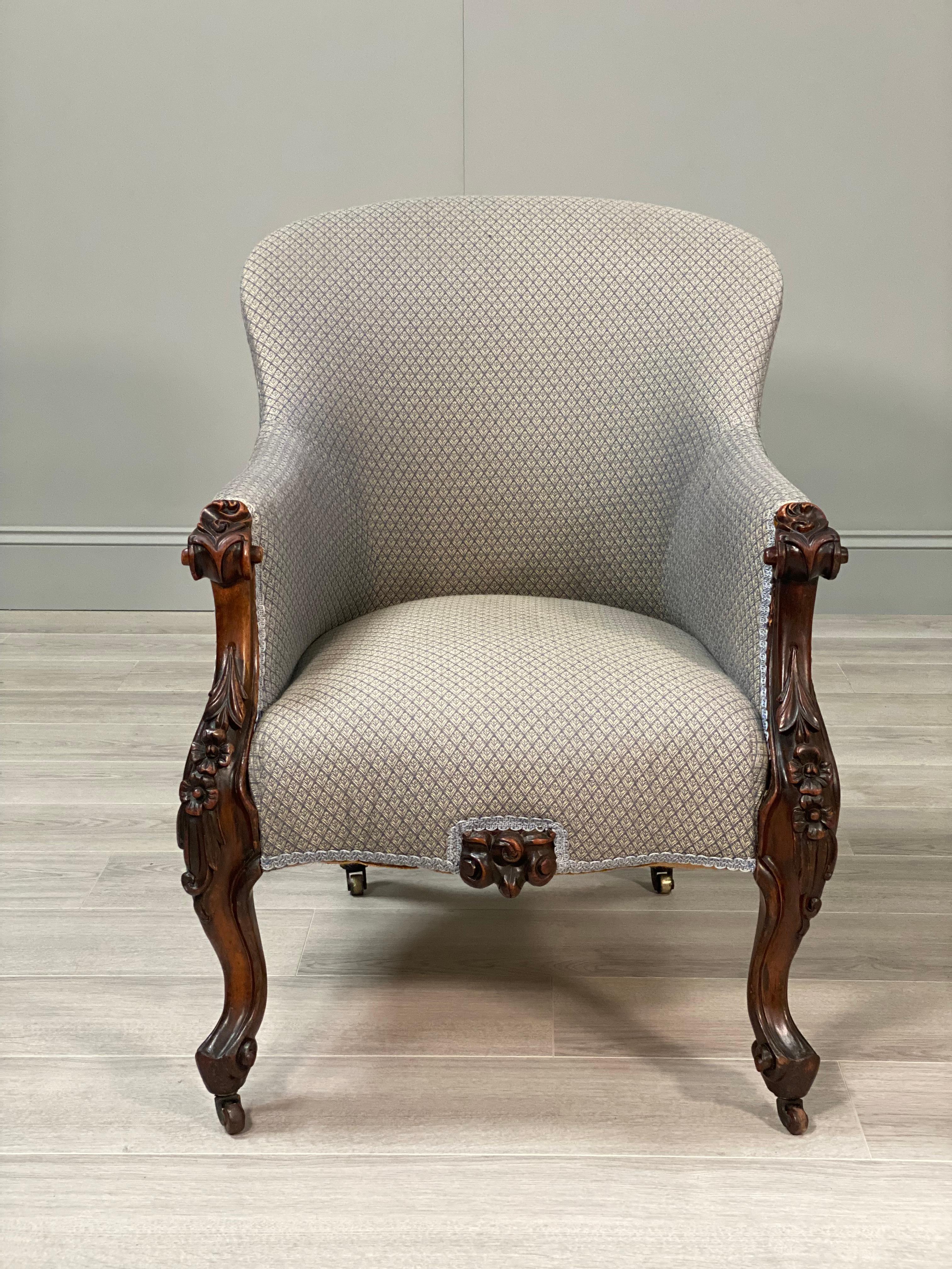 Carved Rosewood armchair dating to the second half of the 19th century. The chair has carved front legs with floral details, a carved centre piece which are all made with solid Rosewood timber. In a traditional upholstery with very little
