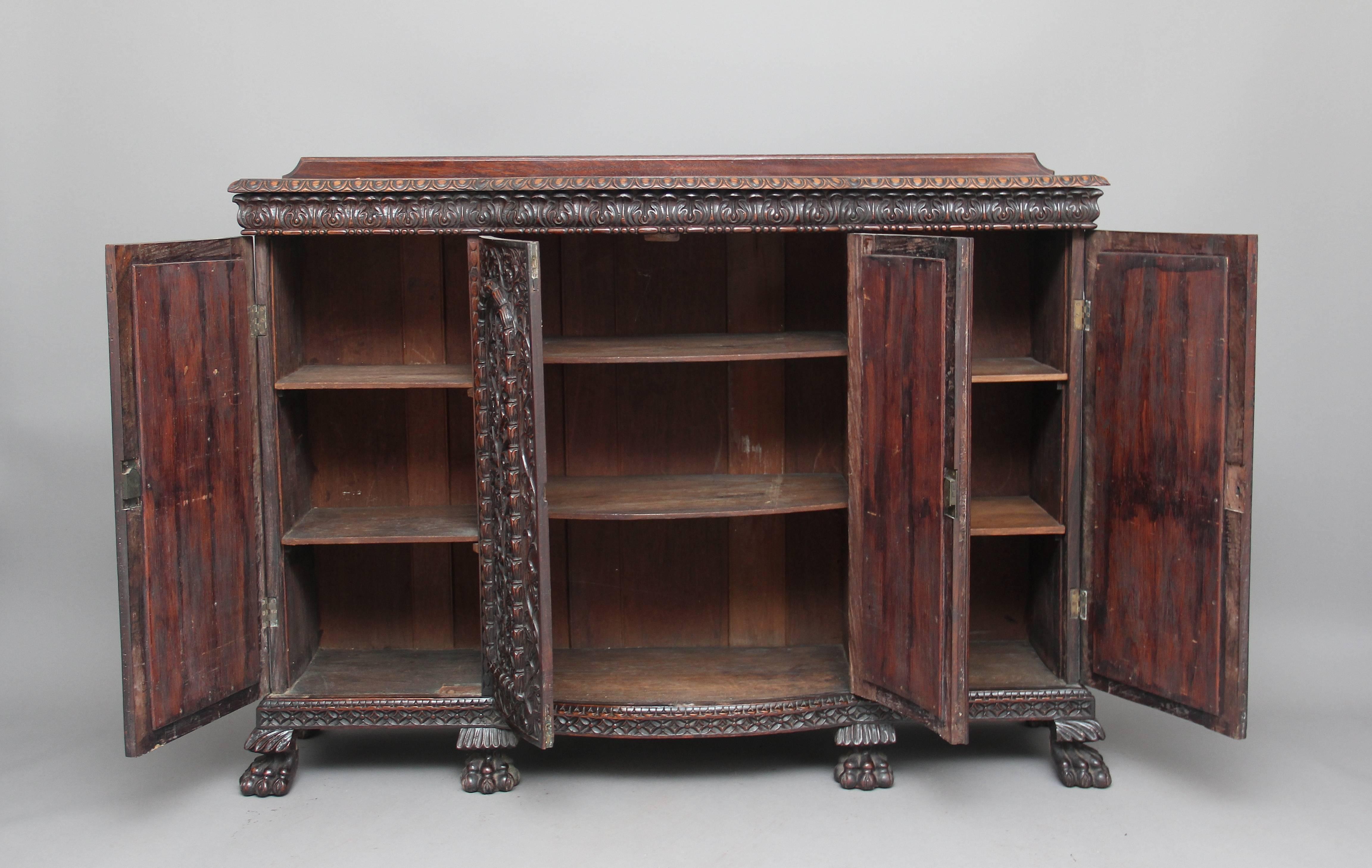 A superb quality 19th century carved rosewood Indian cabinet, the lovely figured shaped rosewood top with a beautifully carved moulded edge, above a shaped frieze with acanthus leaf carving, with four doors below opening to reveal two fixed shelves