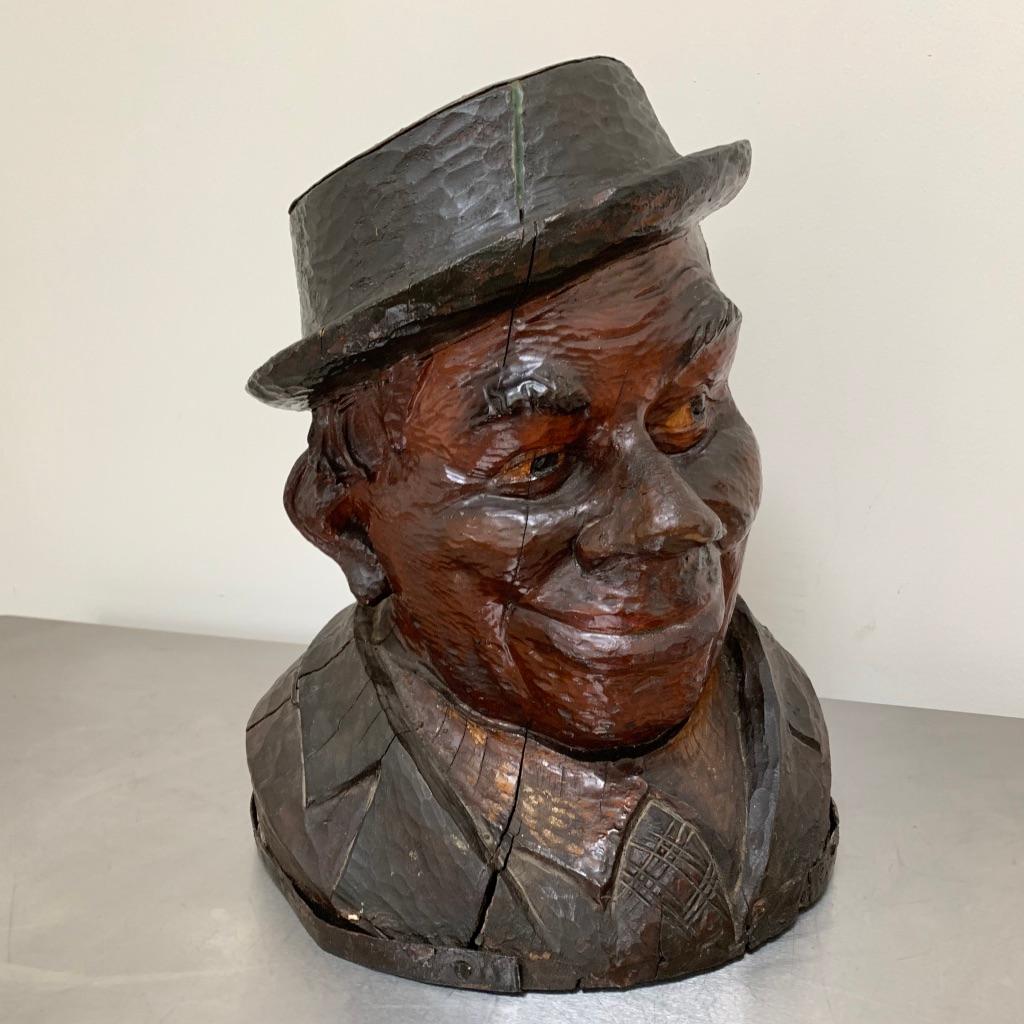 Good decorative 19th century carved sycamore bust of a gentleman with bags of character and a wicked smile!
Carved from a solid piece of sycamore and tinted to finish.
The top of his hat has a studded copper. Lots of age related drying splits