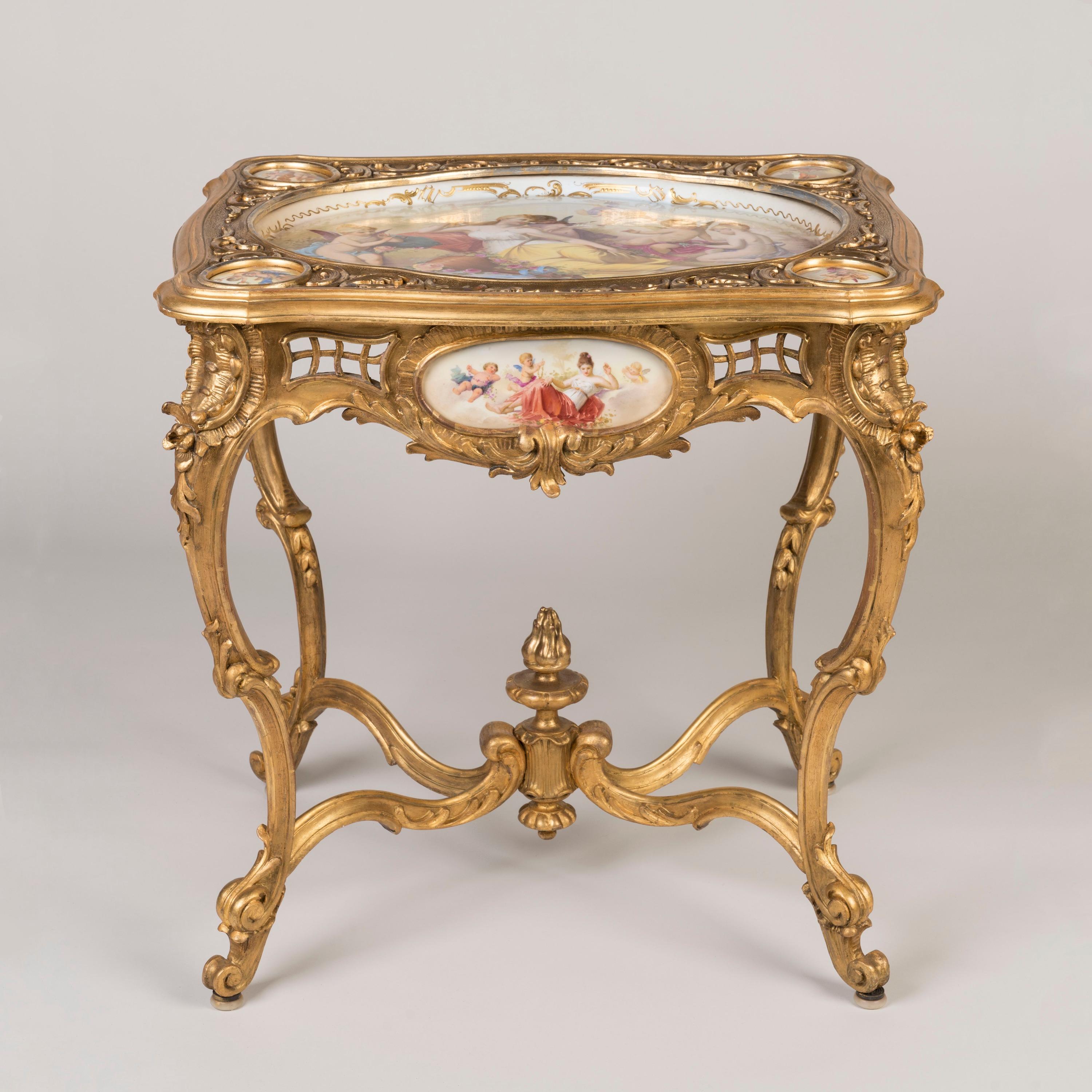 Belle et rare table sculptée en bois doré de style Louis XV
Monté avec des panneaux de porcelaine peints à la main

D'une élégante conception rococo avec une pléthore de courbes en volutes, supportée par des pieds cabriole et des pieds en volutes