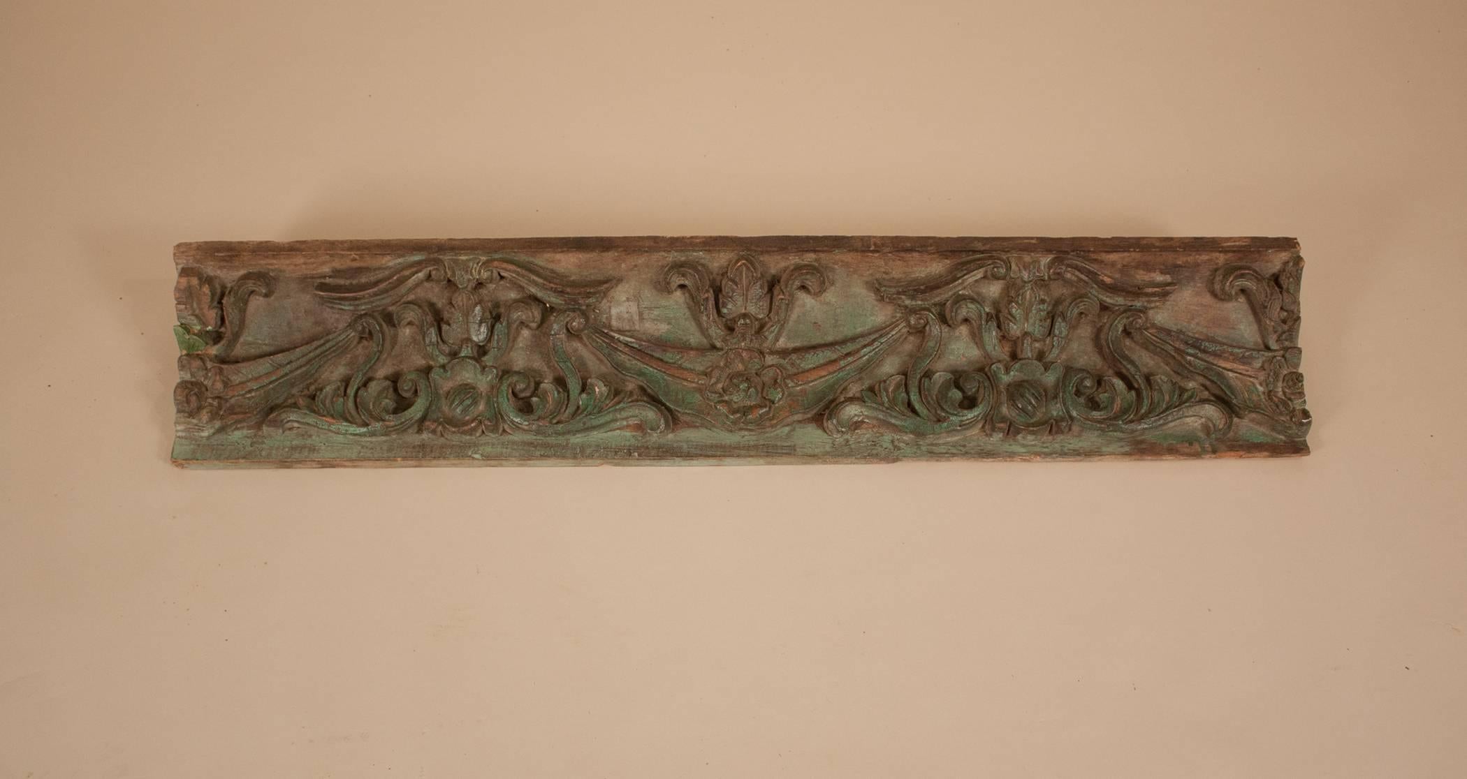 This teak wood architectural panel is carved in deep relief and has its original green paint. Originally a piece of ceiling molding, the fragment was salvaged from a haveli, or mansion, in British India.