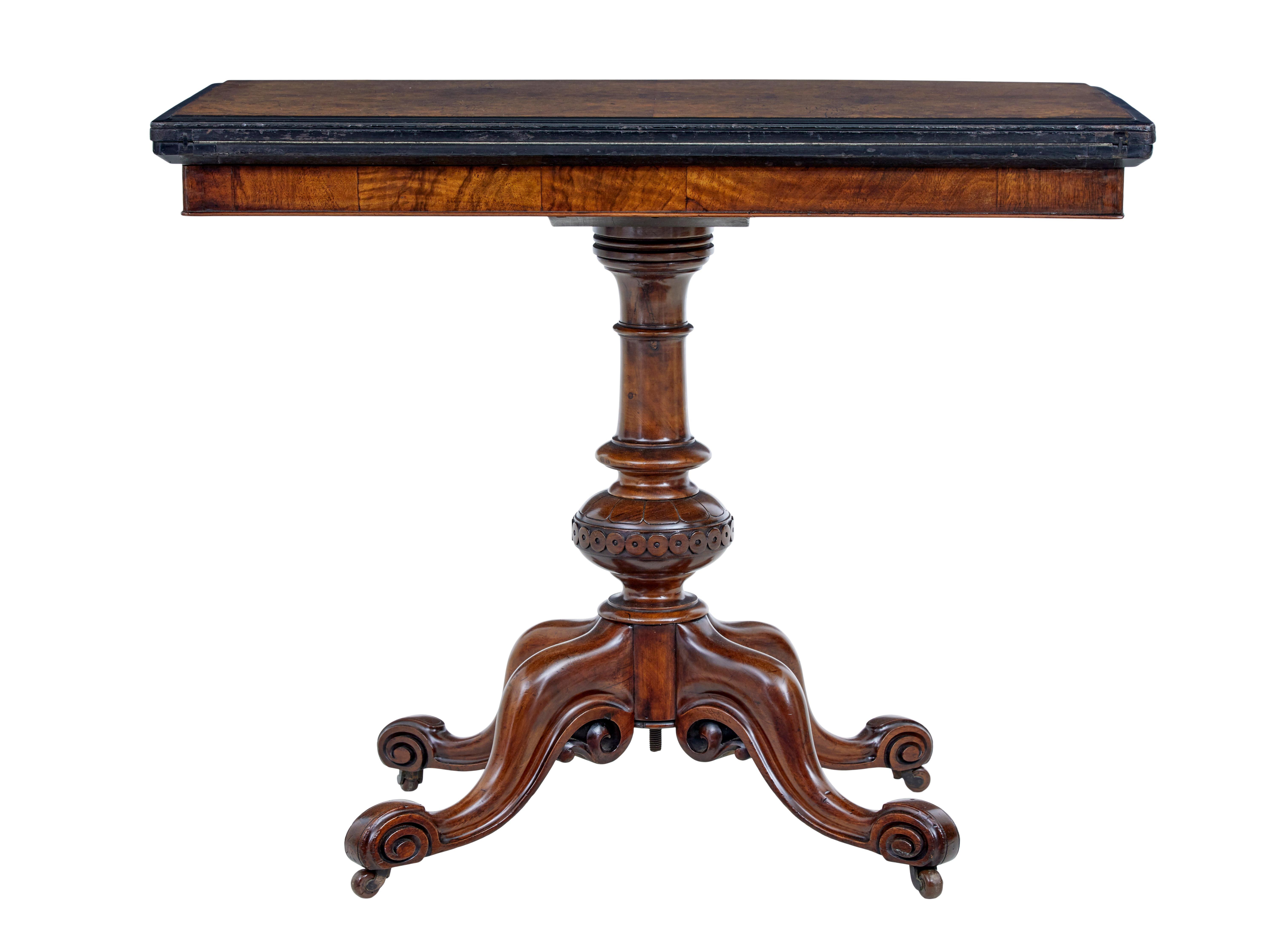 19th century carved walnut and ebonised card table circa 1880.

Burr walnut top with ebonised moulded edge, top rotates to reveal a shallow storage well and open's out to reveal a striking blue baize playing surface.  Stands on a typical high