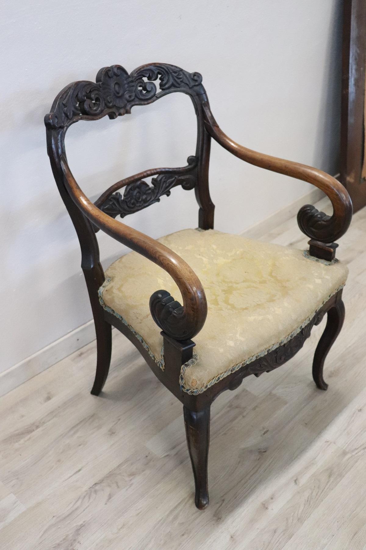 Elegant and comfortable armchair authentic Italian manufacture 1830s. The armchairs are made of solid carved walnut with volute arms. The seat is large and comfortable, ideal for a moment of relaxation, reading or conversation. The armchair are used