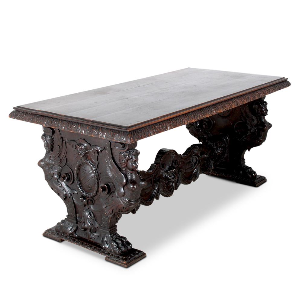 An extravagantly-carved Italian 'Renaissance-Revival' library or centre table in walnut, the double-pedestal base with carved figures, scrolls, swags etc., the pedestals joined by a highly-carved stretcher.
An impressive table for a grand foyer or