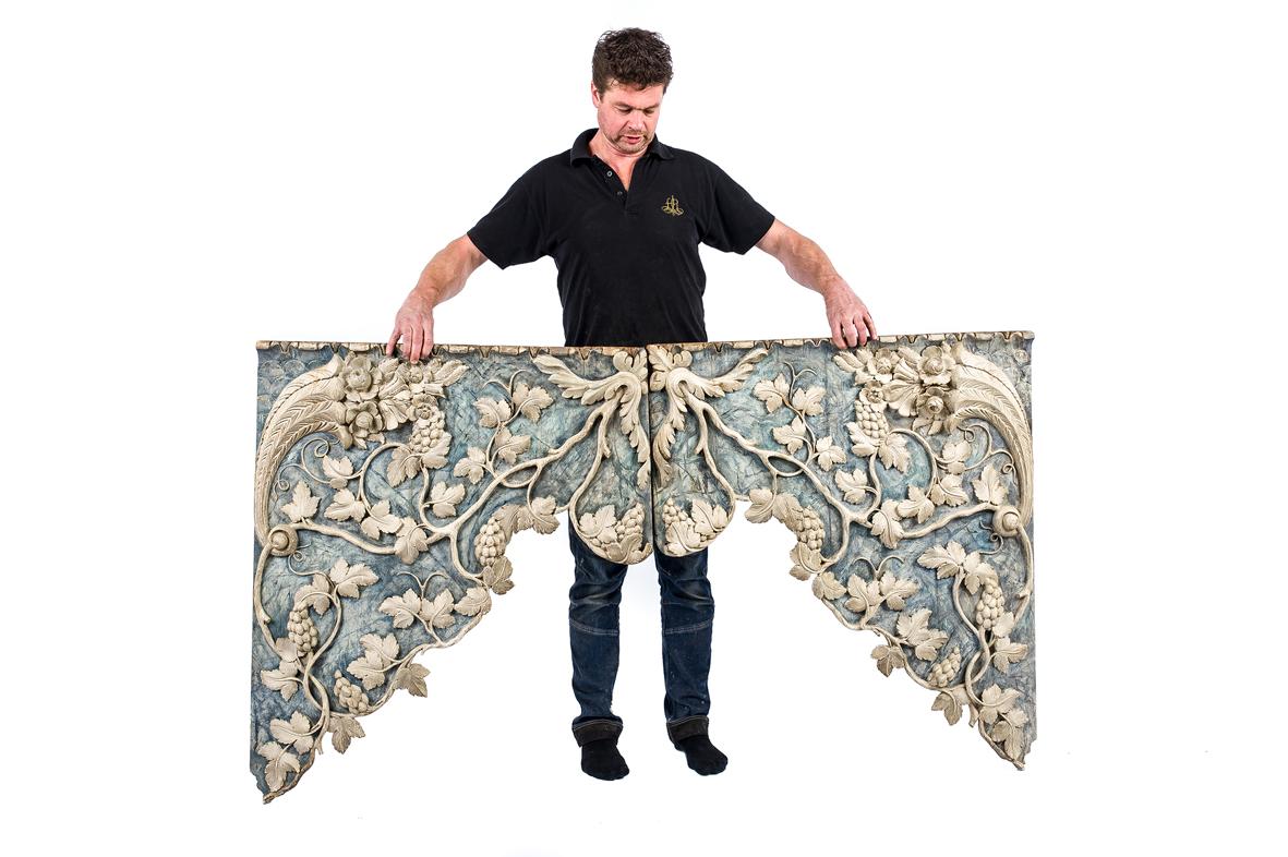 A beautiful architectural pair of hand-carved pine over-door panels or friezes. The panels originate in Northern Italy in the Valpolicella region and date circa 1820. They have the shape of a curtain and were made of solid pine and were decorated