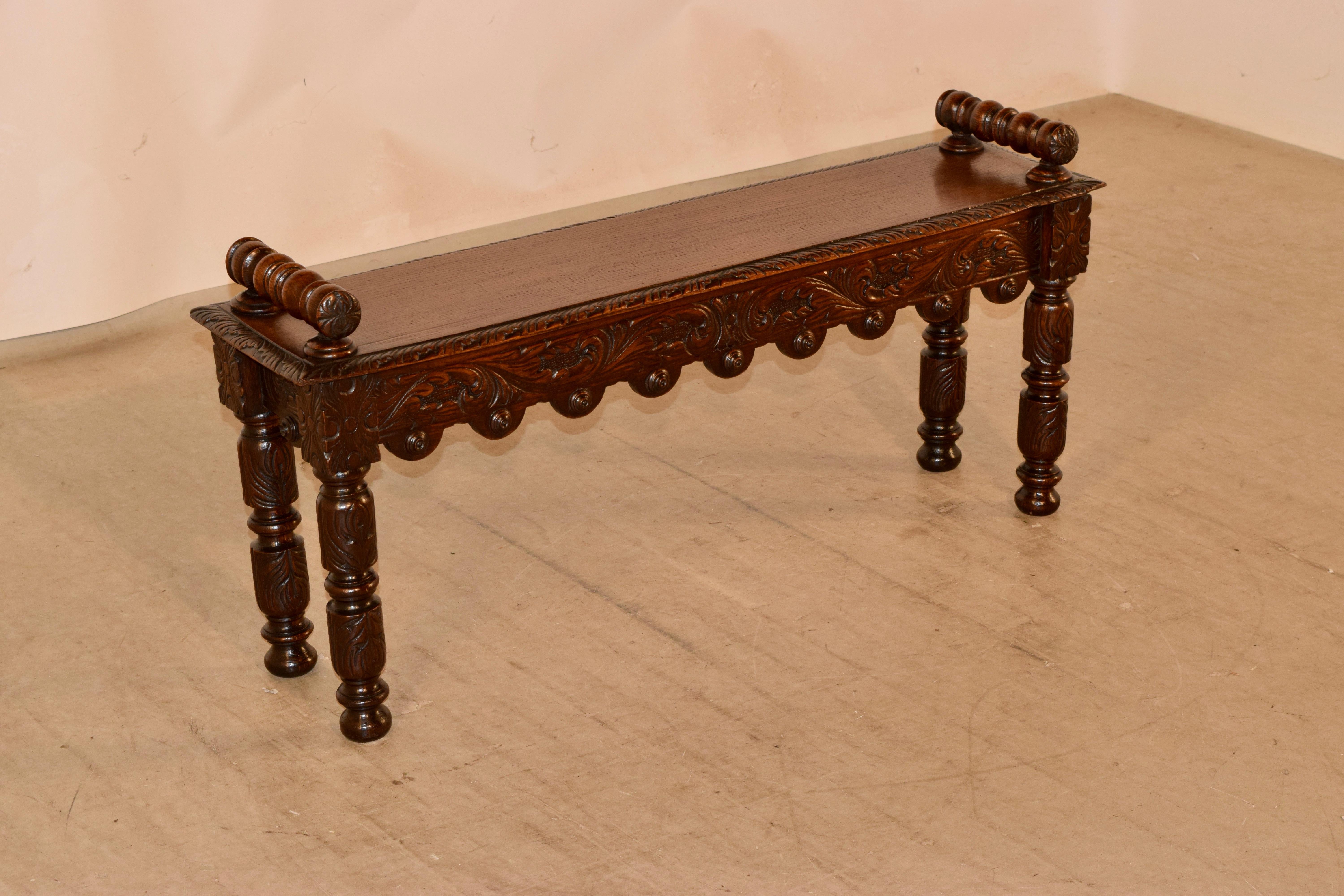 19th century window seat from England. The top is a single board with a beveled and carved edge and has two turned handles attached to the top of the seat. The seat edges have nibbles from honest wear and use. The apron is wonderfully hand carved on