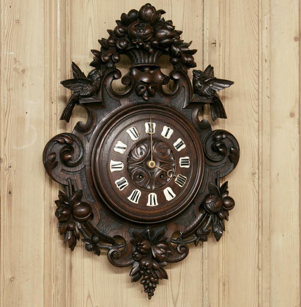 19th century carved wood wall clock features Della robia themes crowned by a basket bursting with the fruits of the earth! Sculpted in a neoclassical motif, it defies the ages with wonderful nature-inspired motifs like lovebirds, fruit, and flowers