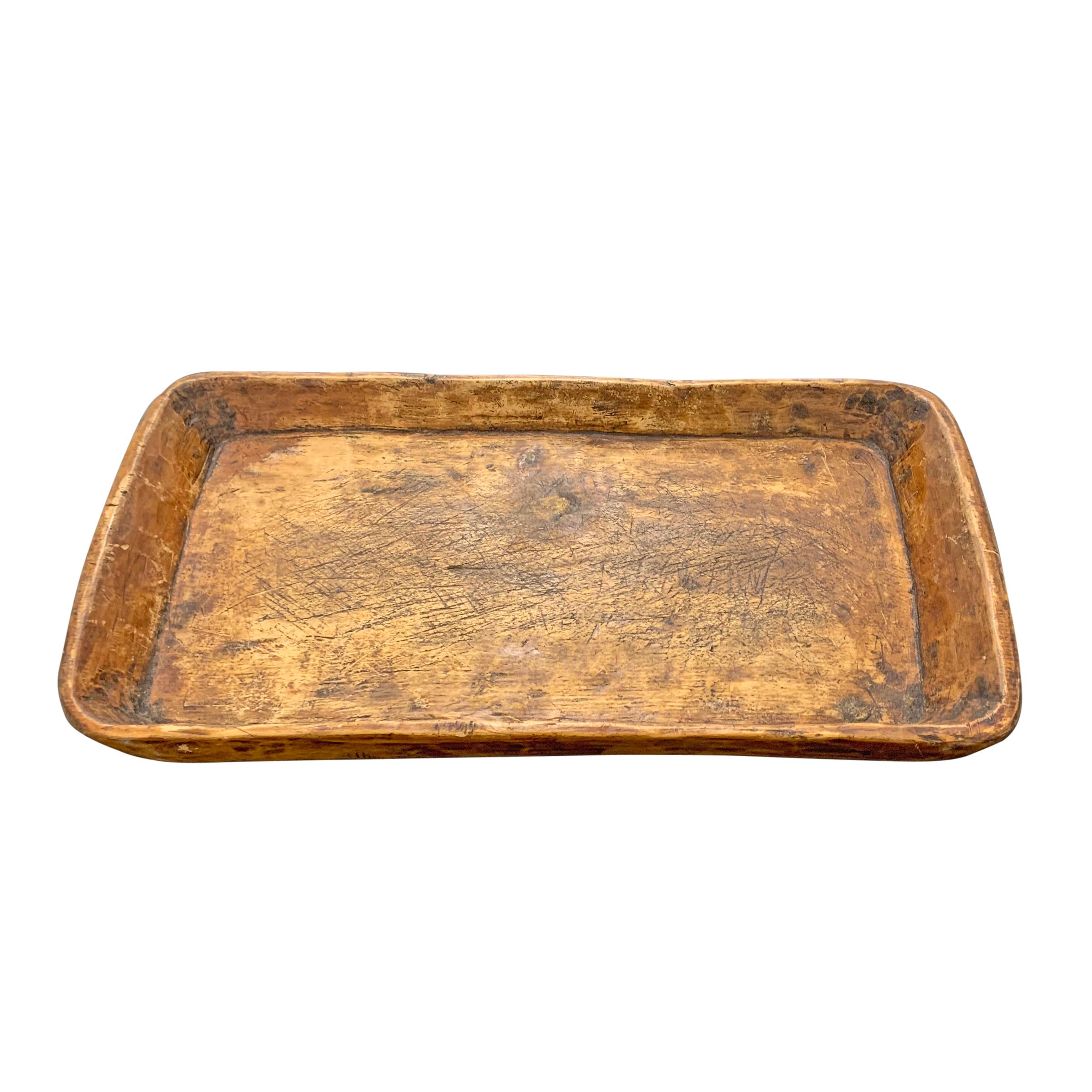 A wonderful 19th century tray hand carved of one piece of wood, with slightly tapered walls, myriad knife marks, and a wonderful patina only time can bestow. Perfect for serving foods at your next party, or collecting the day's mail on a table in