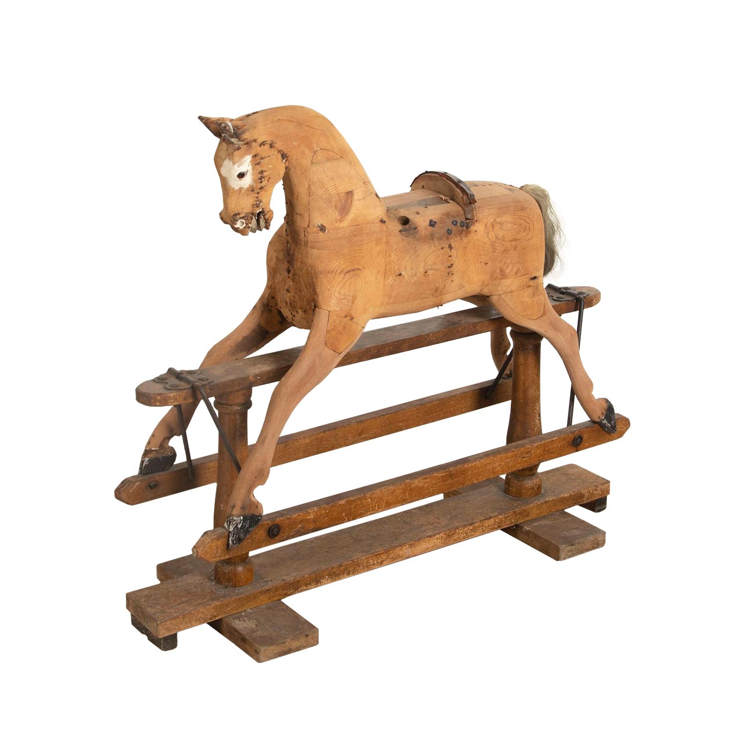 Cheval à bascule en bois sculpté du 19e siècle sur une bascule fonctionnelle. Cette pièce a de bonnes proportions et une patine avec des yeux en verre d'origine.
 