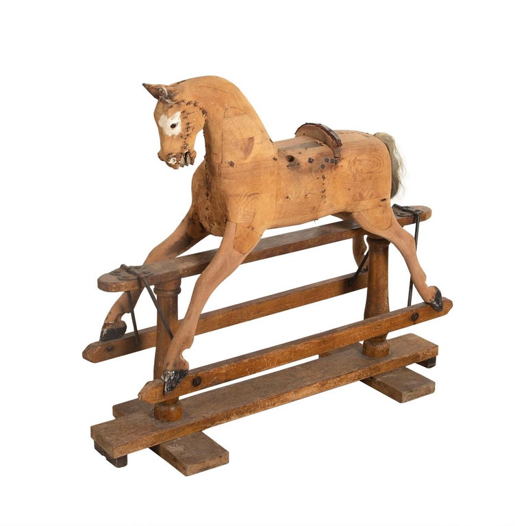 19th century carved wooden rocking horse on a working rocker. This piece has good proportions and a patina with original glass eyes.
 