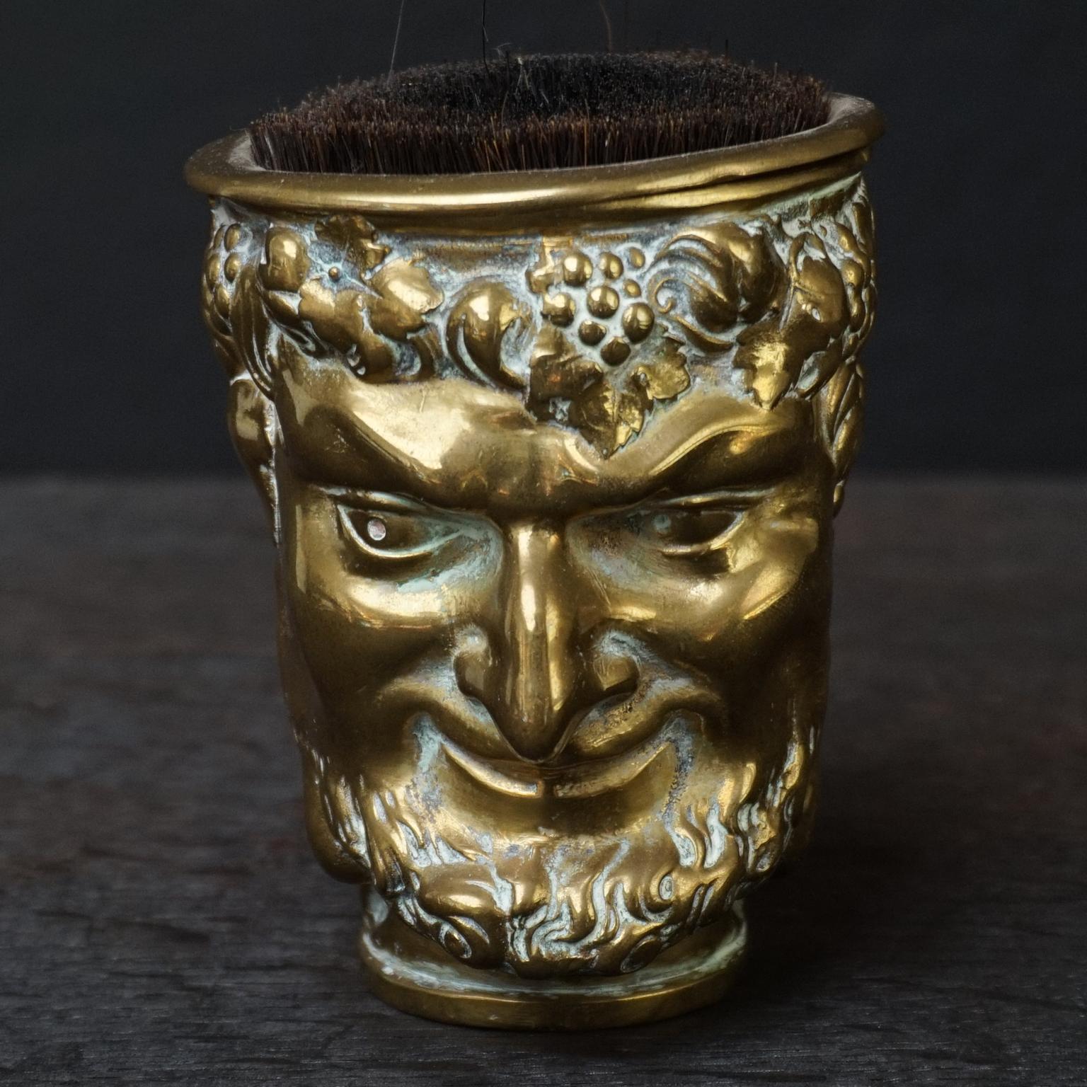 Antique heavy cast brass satyr with grapes and grapevines in his hair.
With this grape and leafage it easily could be Bacchus and his pointy ears make him also a pan kind of figure.

This cup is not as big as the drinking cups you see with the