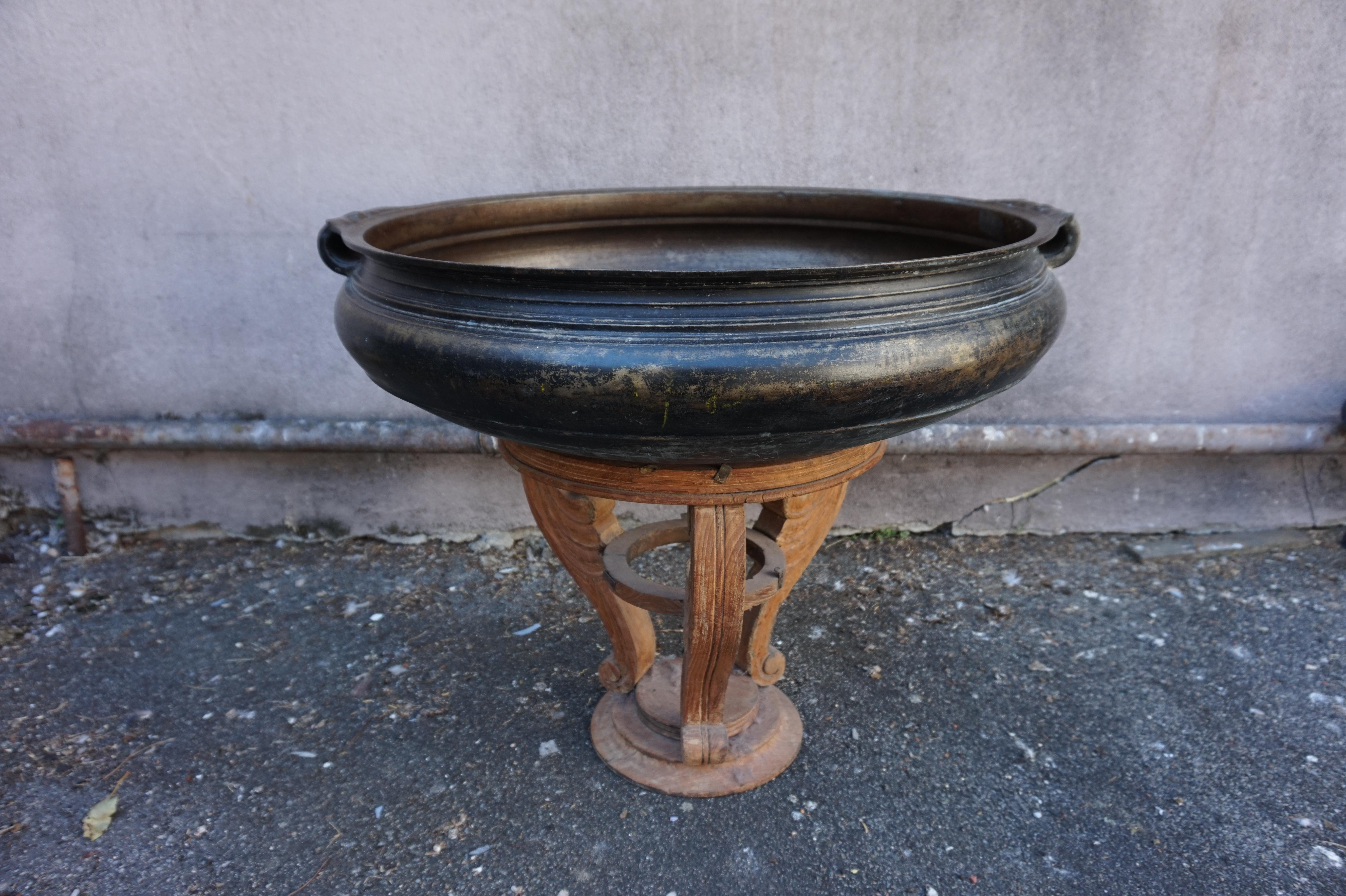 Large cast bronze vessel originally used as a ceremonial cooking urn. This specific piece was beautifully cast with turned rings and moulded handles. It also features original patina and that really adds to it's appeal. Fill with floating flowers as