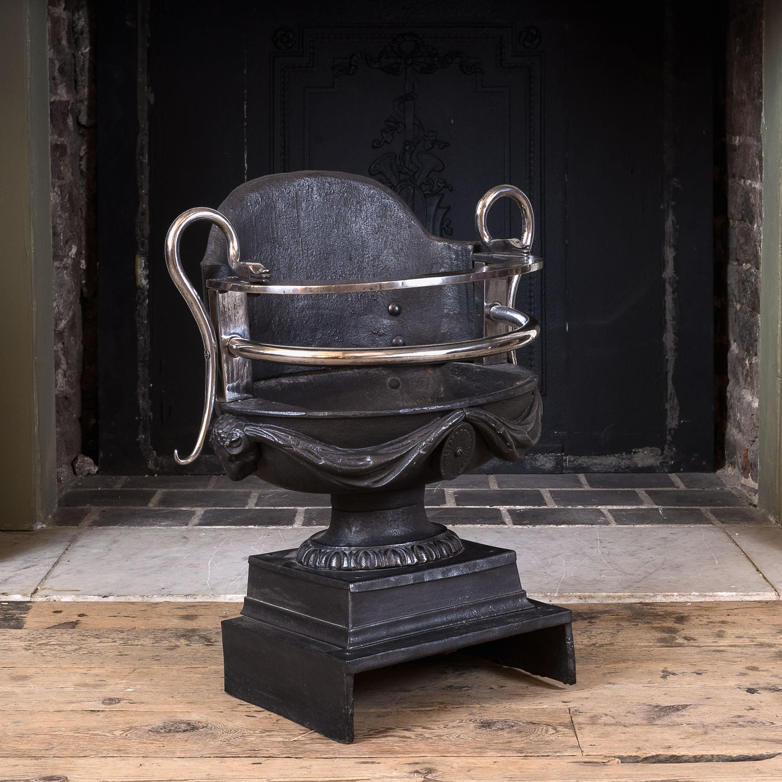 Nineteenth century cast iron coal grate, the handles formed as scrolled serpents, the urn grate with swagged pelmets flanking oval paterae, on plinth base.

Base is 25 cm x 32 cm.
