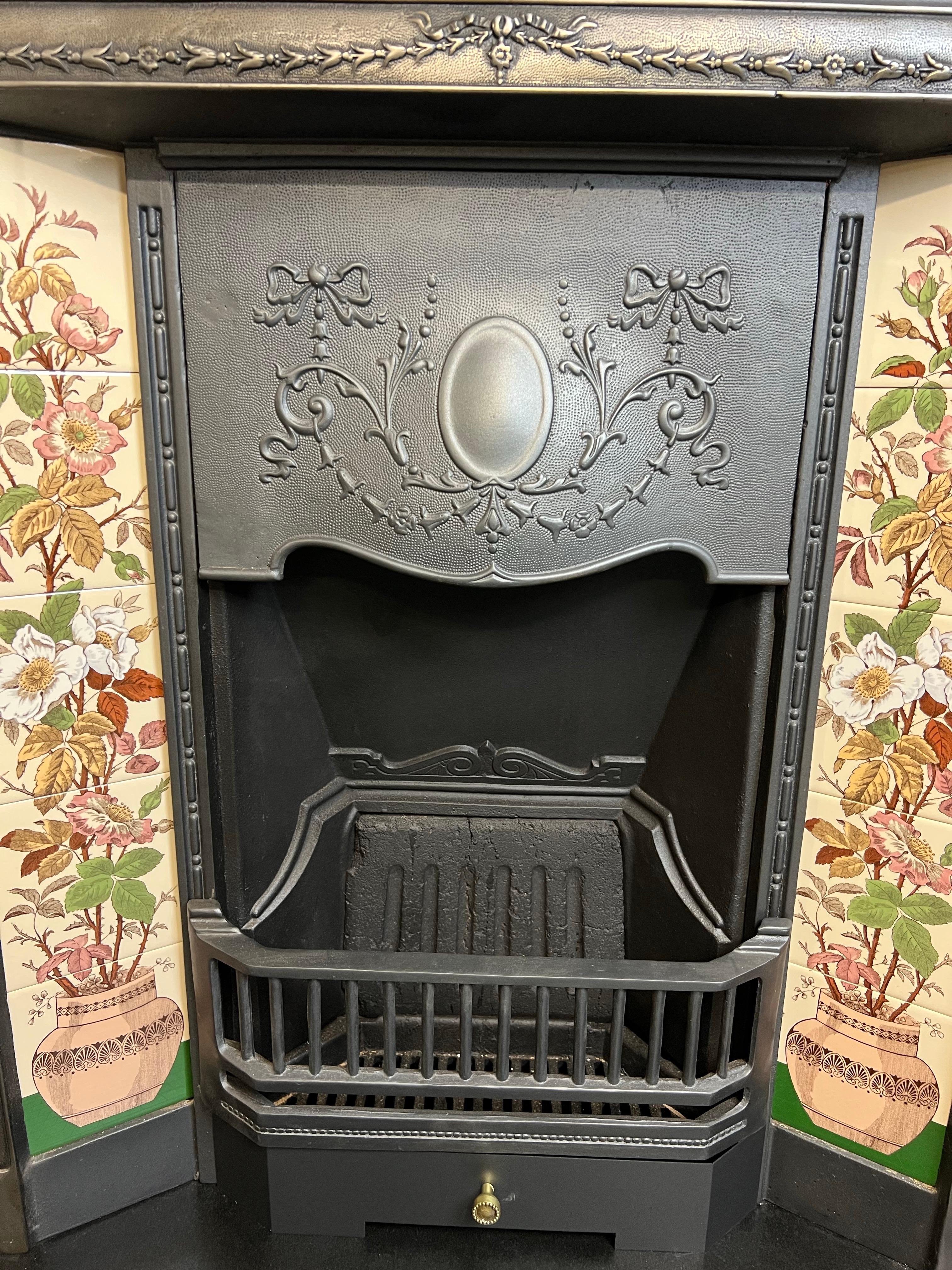Chimenea de hierro fundido del siglo XIX.
Original chimenea victoriana de hierro fundido de fabricación inglesa.
Acabado ennegrecido con barras delanteras, capó y parte trasera. 
Incluido Juego De Baldosas De Cerámica Pintadas Firepalce De Rosas