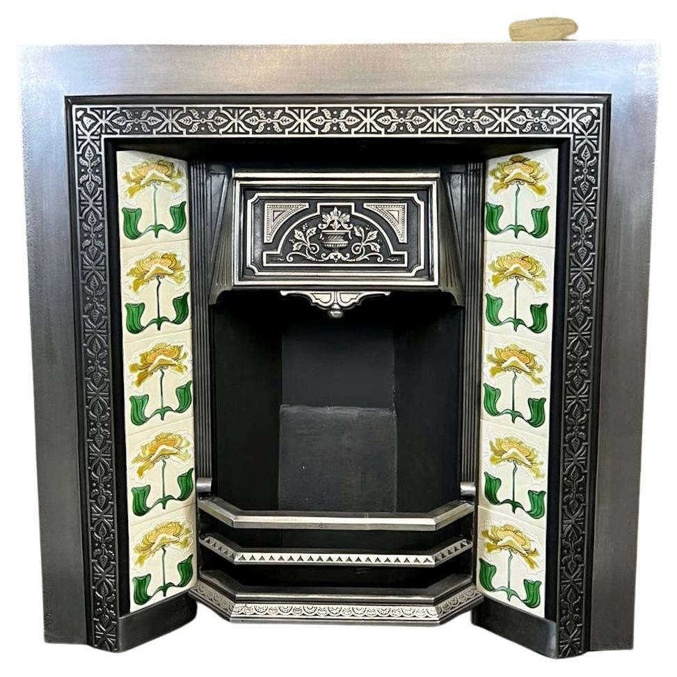 19th Century cast iron tiled fireplace insert.
Complete with fire back, front bars, decorative floral & urn pattern hood, and set of embossed hand painted water lily tiles.
Recently salvaged from a London Victorian house. This fireplace presents