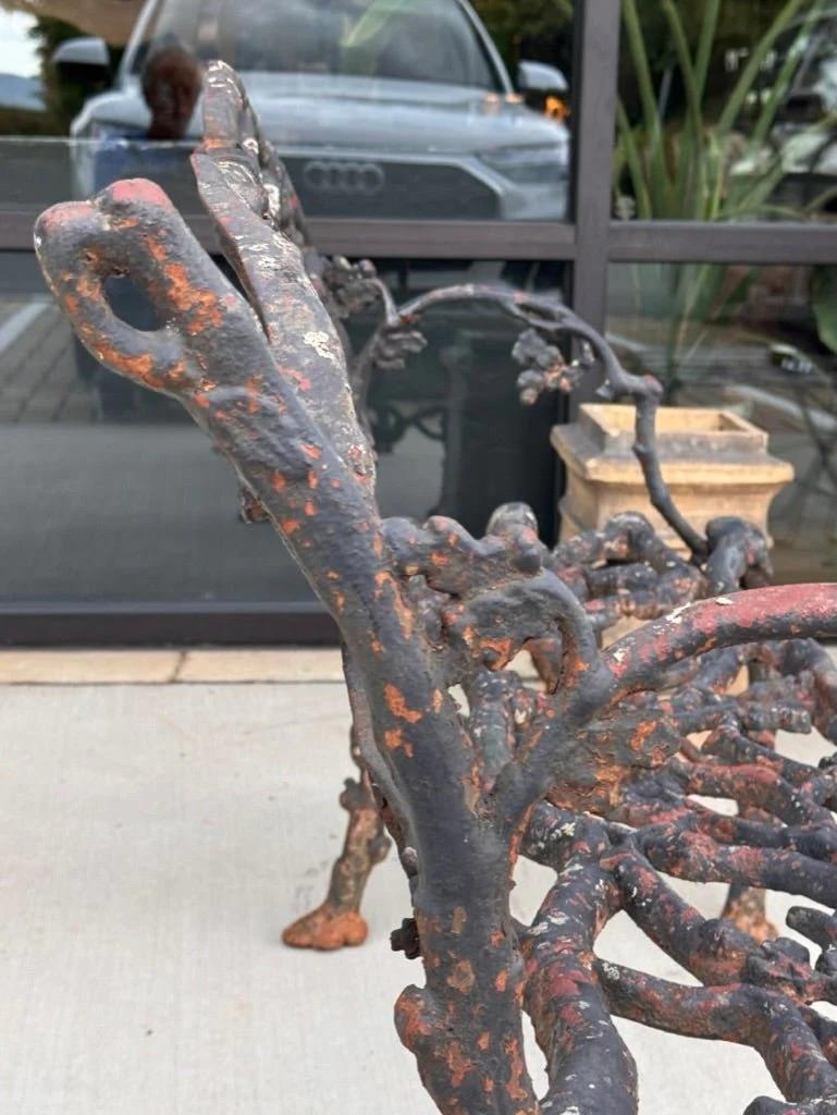 Cast iron Garden Bench / Settee, cast in four sections, entirely of intertwined oak branches with acorns and leaves, raised on conforming trunk legs joined by entwined serpents. Retains an old black-painted surface. Probably Janes, Beebe & Co., New