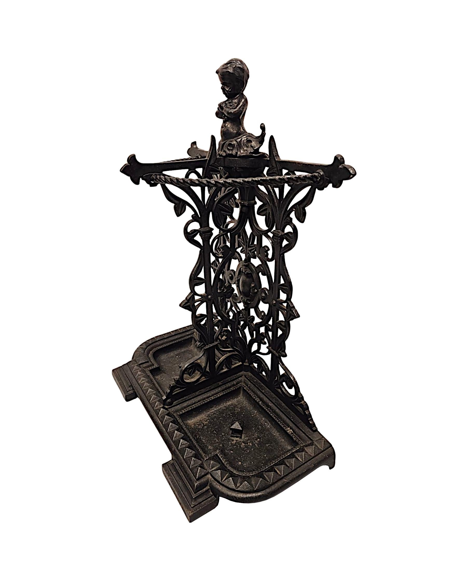 Uno splendido portaombrelli o bastone in ghisa pesante del XIX secolo di qualità eccezionale.  Il supporto posteriore traforato e finemente lavorato, sormontato da un cherubino, è decorato in modo intricato con splendidi motivi di foglie, volute e