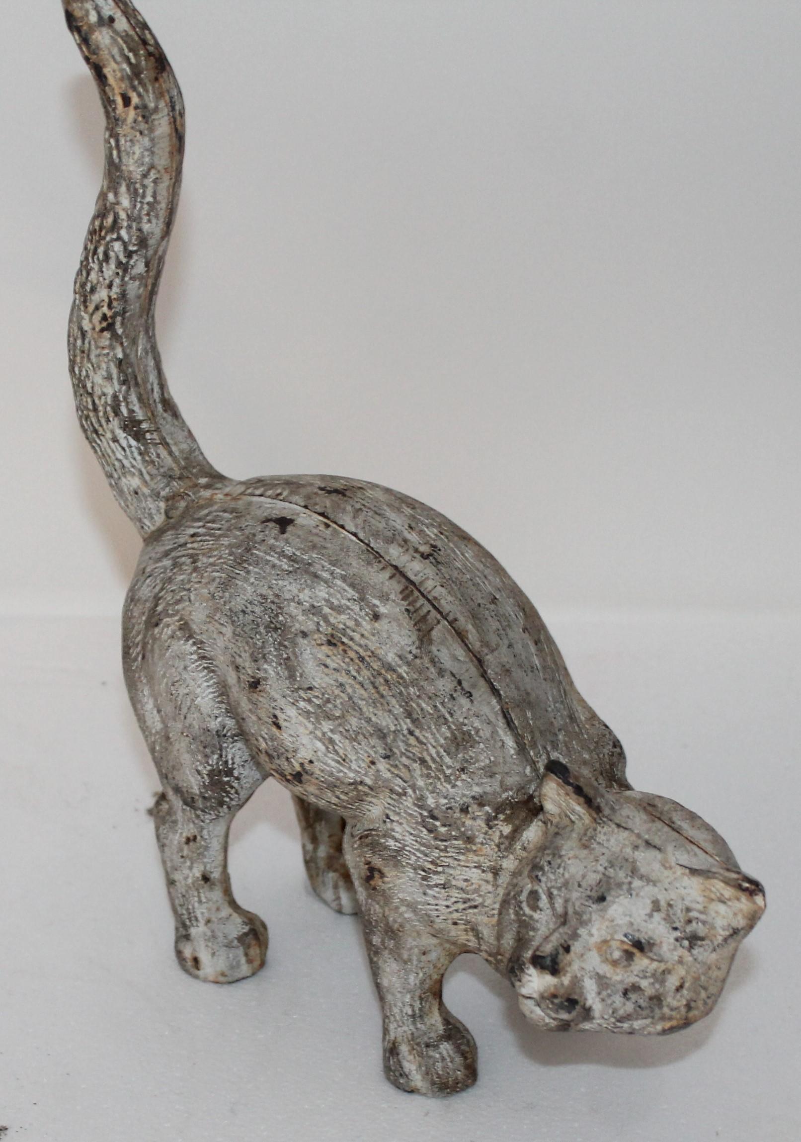 This original white painted cast iron cat looks like a Hubley but it is unsigned as well. The worn and distresses paint is consistent from age and use.