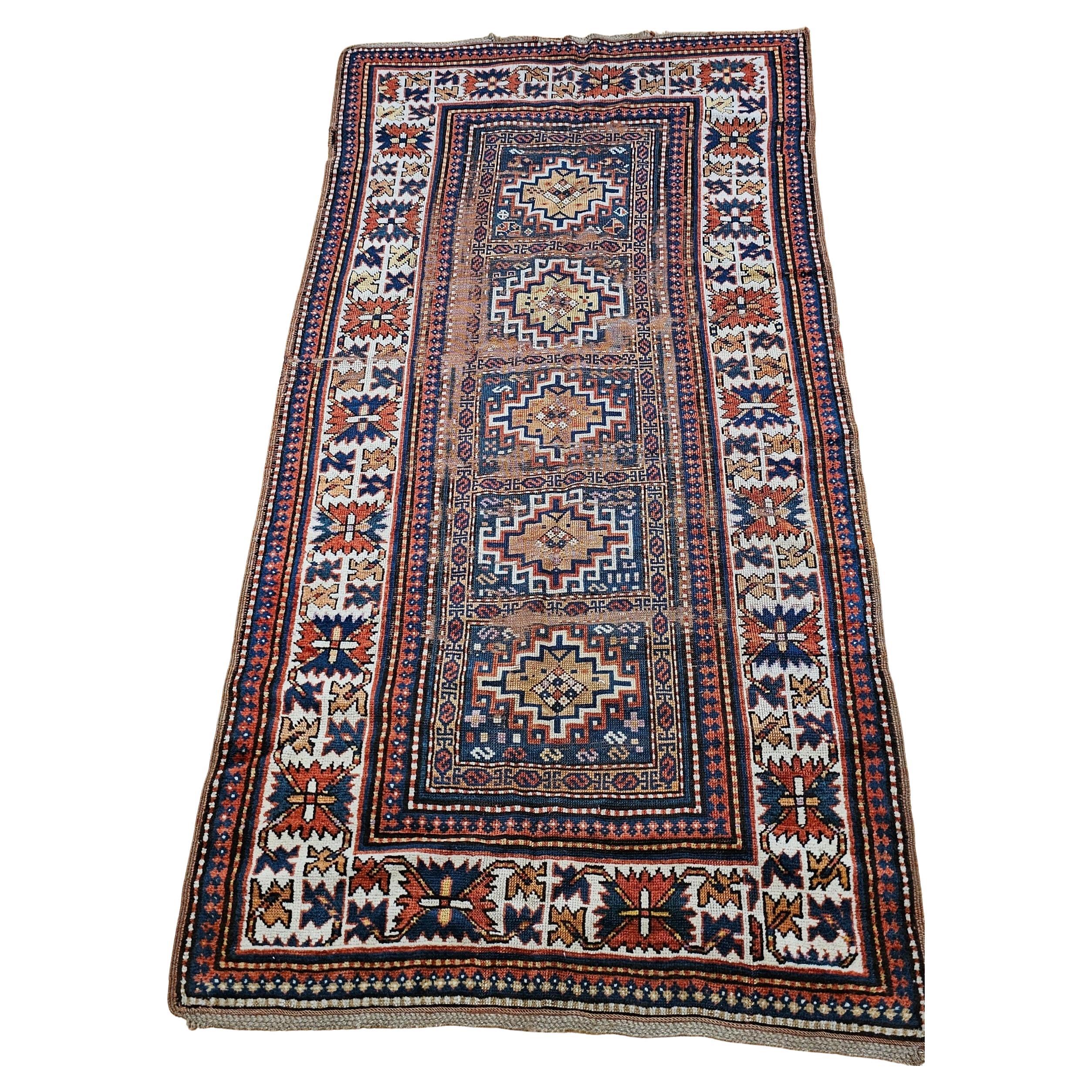 Alfombra kazaka del siglo XIX con motivos geométricos en azul, marfil y rojo