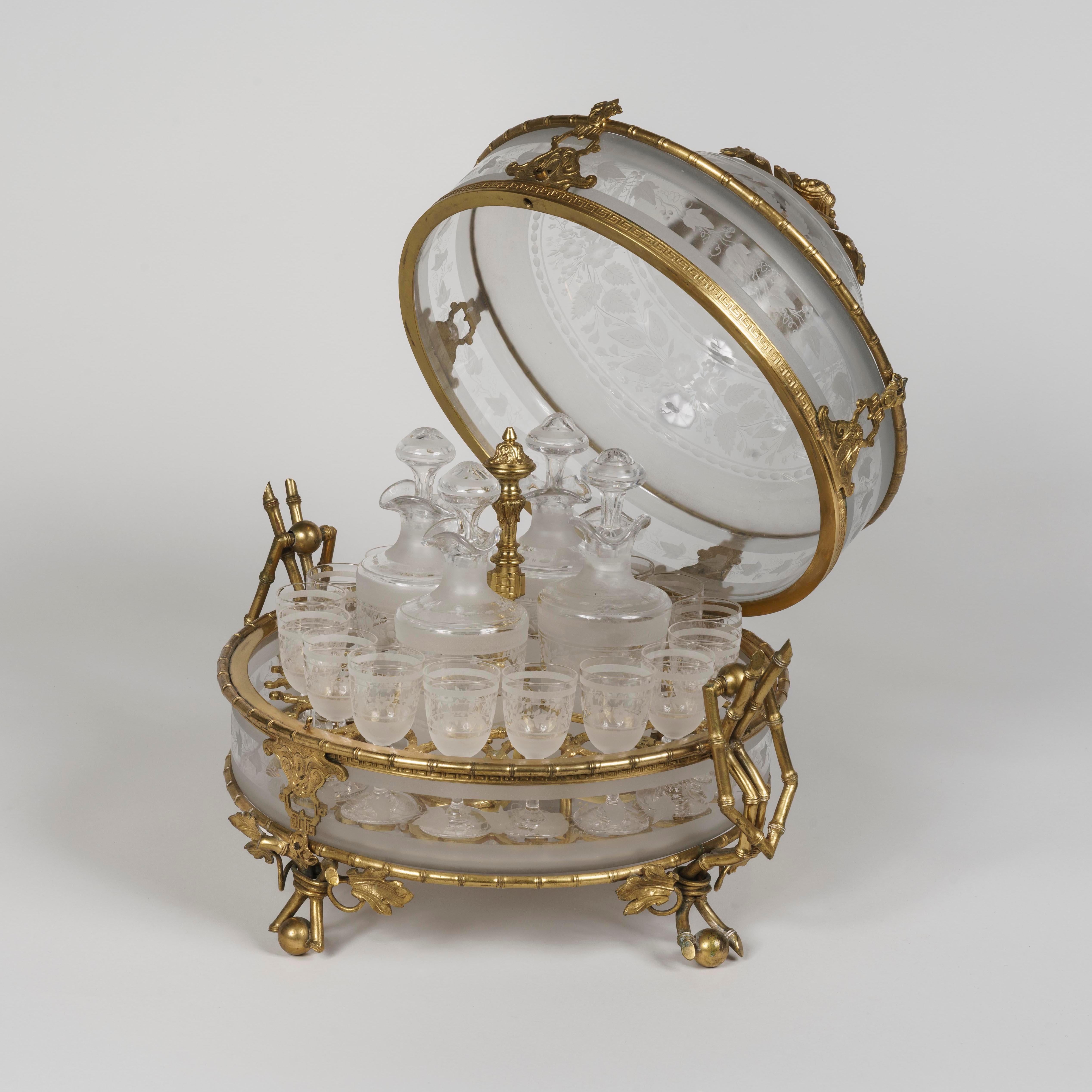 Cave à Liqueur in the Japonisme Manner
Firmly attributed to Baccarat

Entirely complete and constructed of gilt bronze with glass, frosted and engraved; of lidded and lockable circular form, the glass cage enclosed in a 'bamboo' framework, and