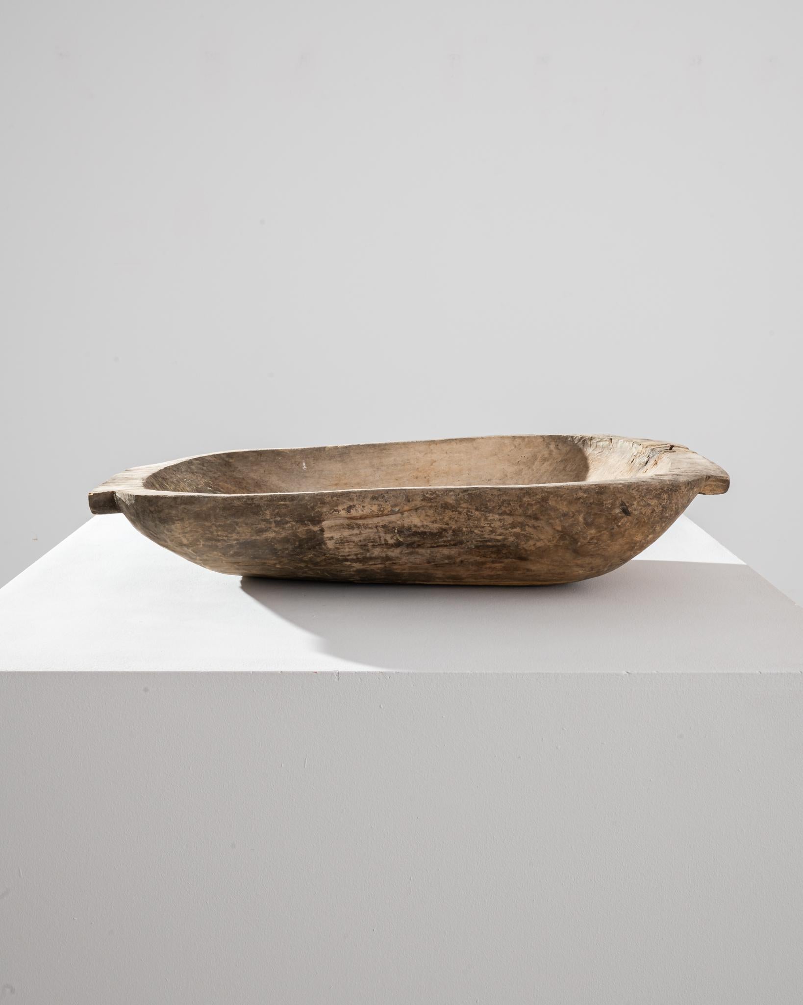 The simple form and tactile surface of this wooden bowl give it a timeless appeal. Made in Central Europe in the 1800s, the rough-hewn texture indicates that this piece was carved by hand from a single piece of wood, formerly used to store rising
