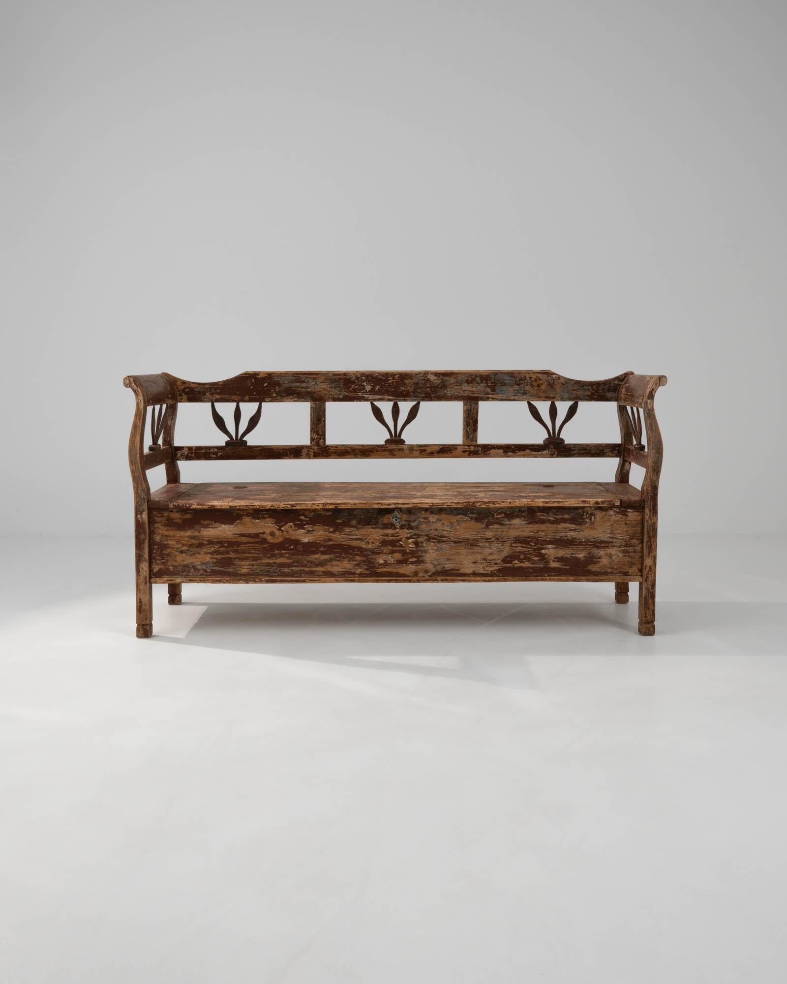 Embrace the rustic charm of history with this 19th Century Central European Wood Patinated Bench. Its beautifully distressed wood tells stories of times past, making it not just a piece of furniture, but a conversation starter. Featuring artfully