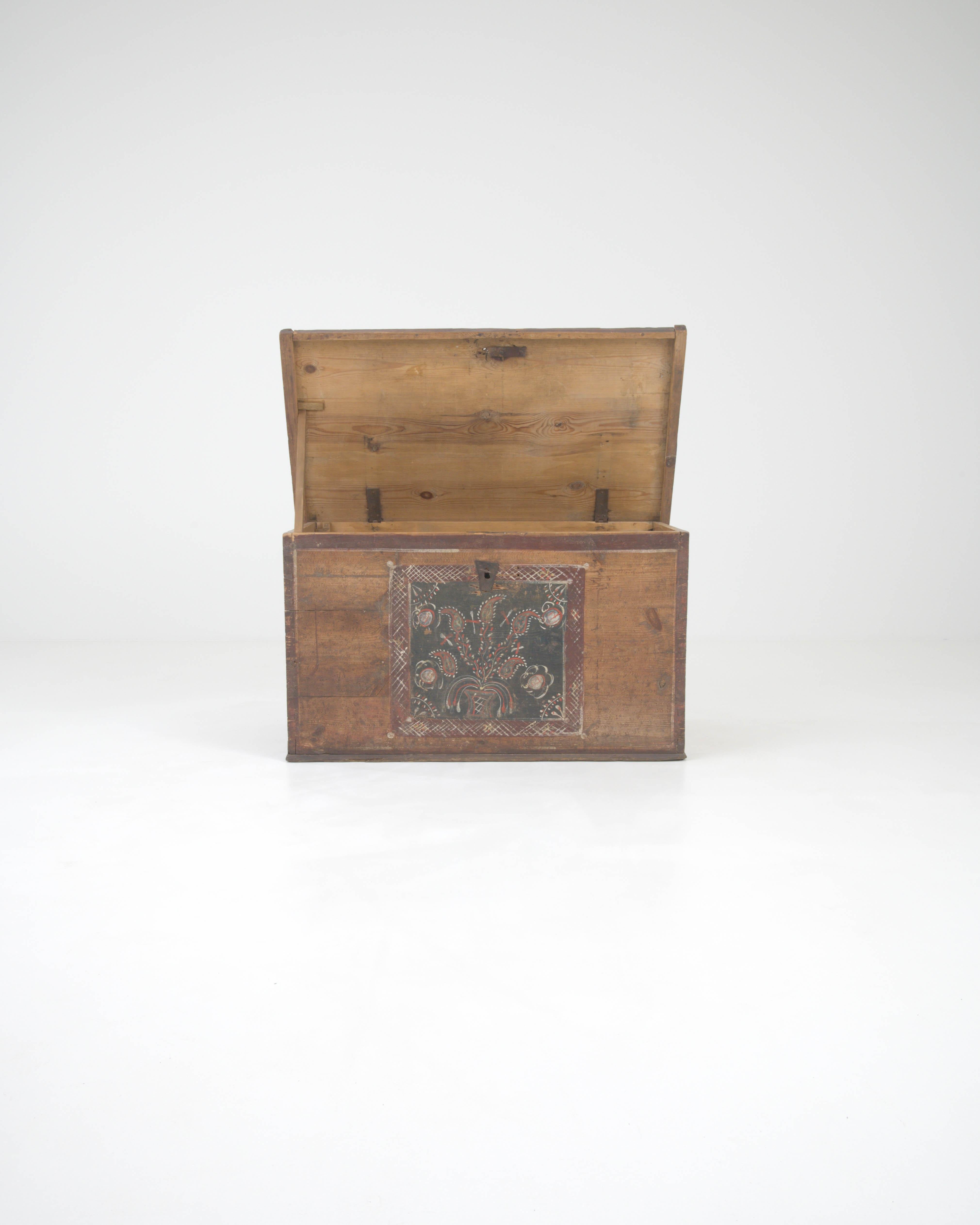 Behold a piece steeped in history—the 19th-century Central European Wooden Chest. Each corner of this venerable chest is etched with the patina of time, its surface bearing the hallmarks of countless stories. The front panel is adorned with a
