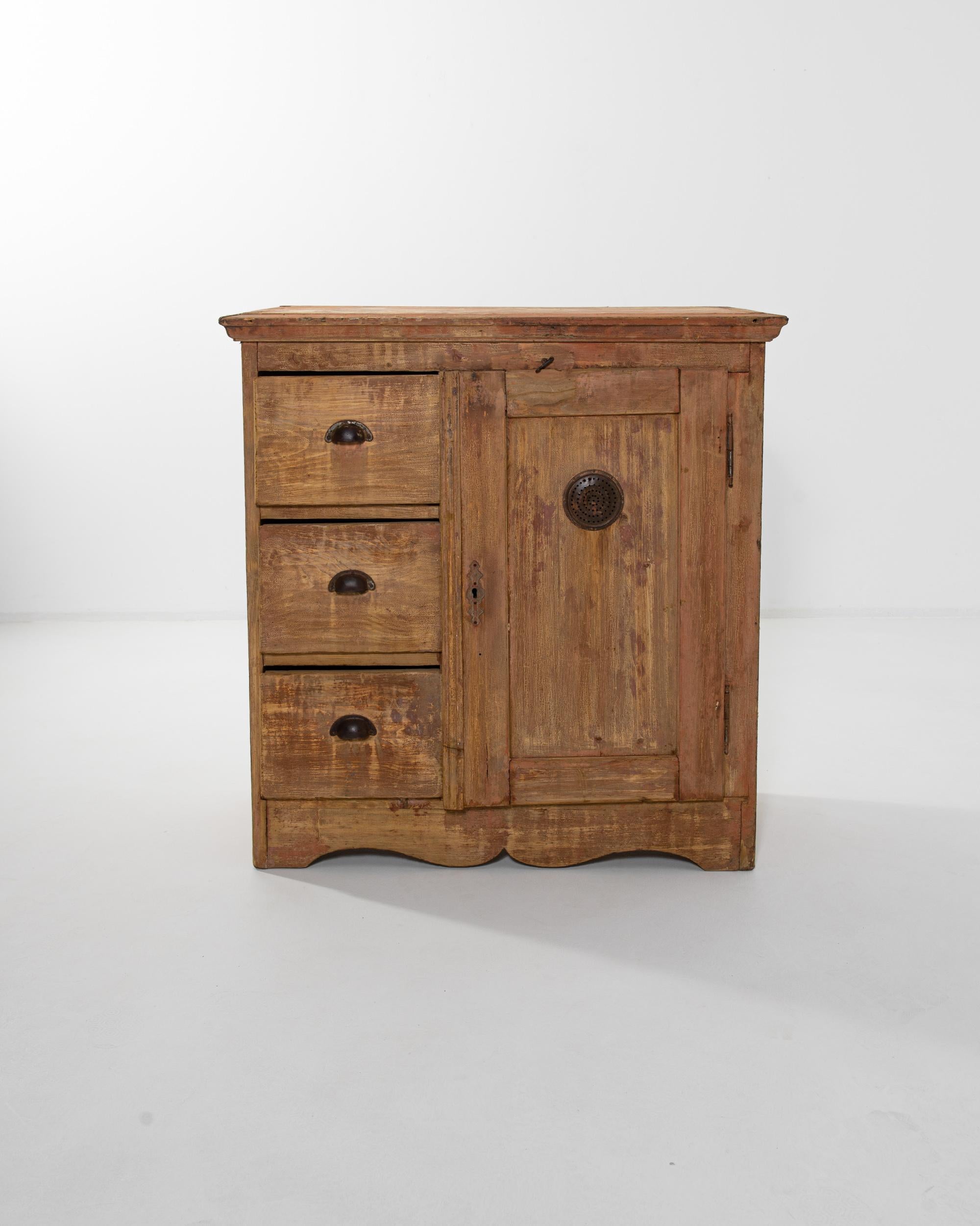 An antique wooden buffet with a country charm. Built in Central Europe in the 19th century, a perforated metal disk set in the cupboard door indicates that this piece would have once been used as a larder, allowing air to circulate to keep