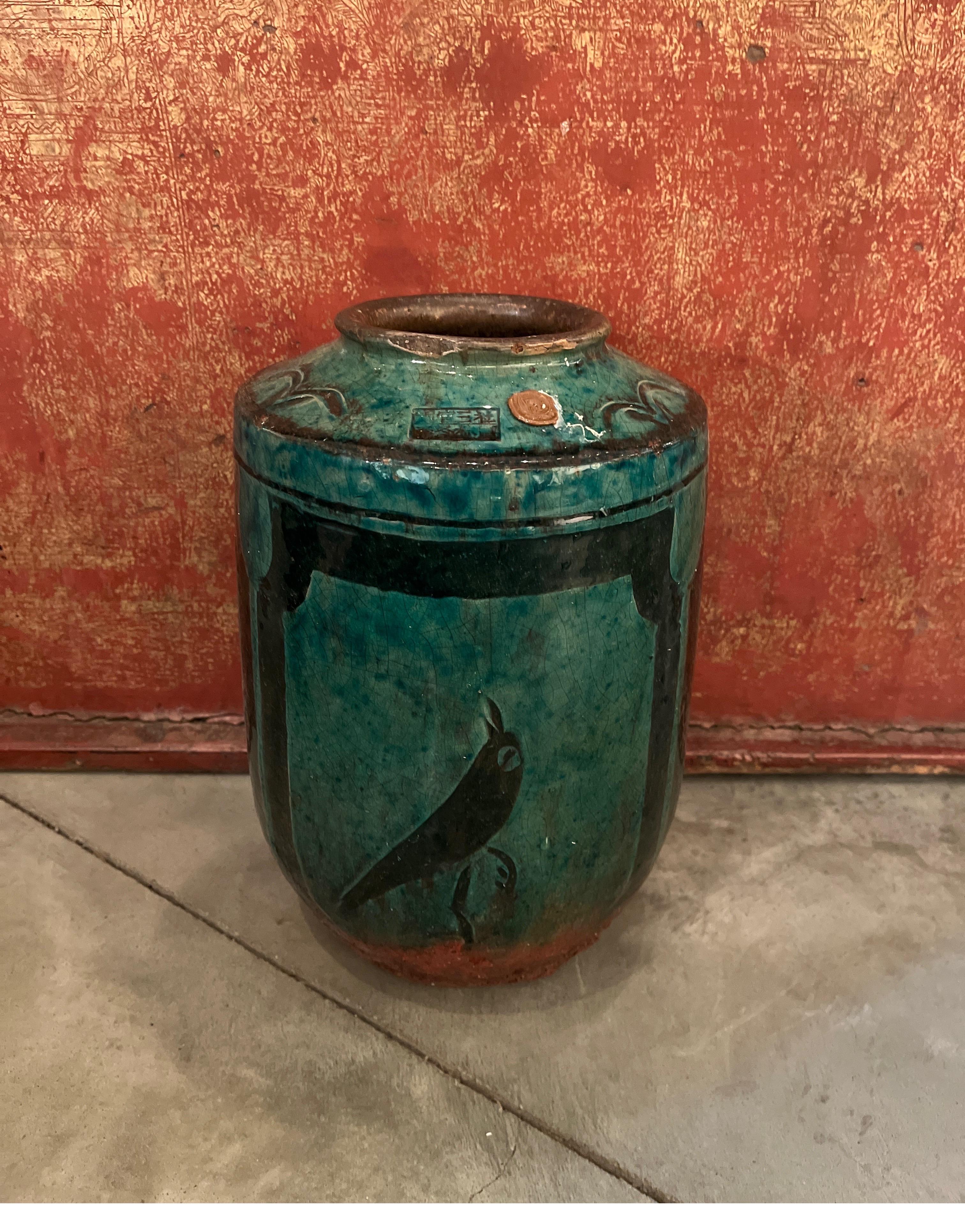 A beautifully glazed 19th Century Chinese ceramic food jar, emerald green in color, with a striking hand painted image of a bird, and two hand painted floral images.   This vase will stand out on a shelf or tabletop as an unusual, colorful and