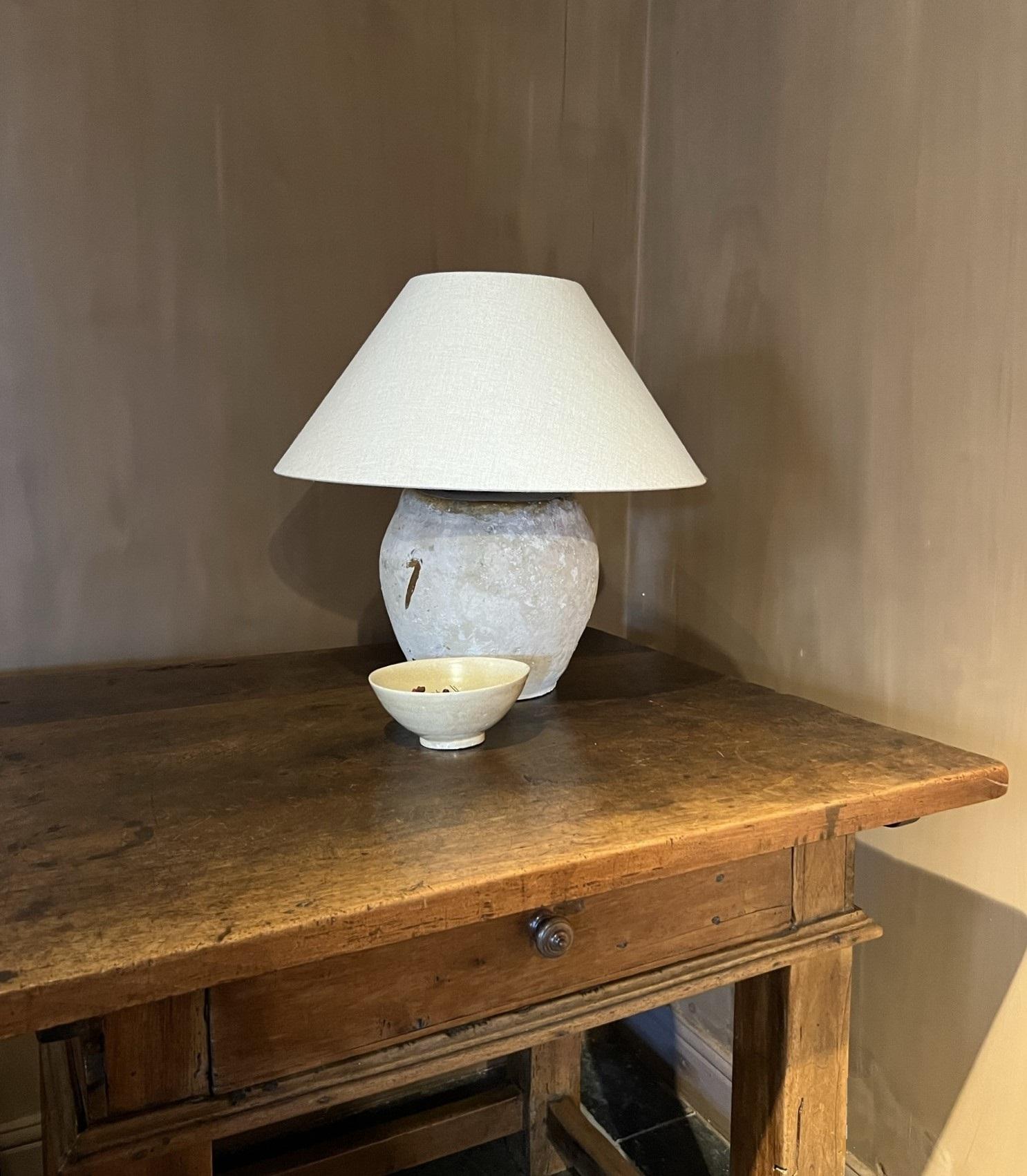 A 19th century ceramic vase turned in to a tablelamp. These pots were used, particularly in the South of France, to provide breeding nests for pigeons in barns and sheds. As they are flat at on side they stack easy in to a large piramidshape. 
These
